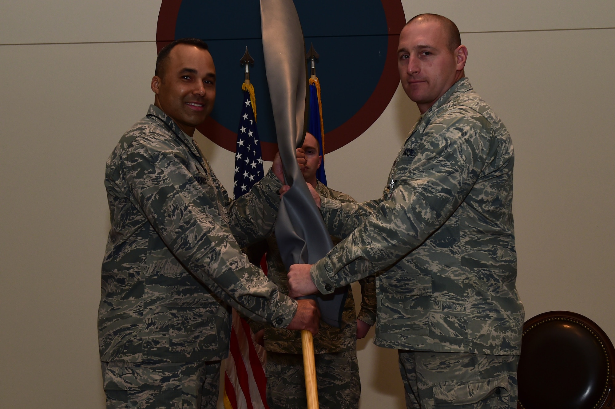 Lt. Col. Craig Thorstenson, 460th Operations Group, Detachment 1 commander, passes the rolled up guidon to Col. Lorenzo Bradley, 460th Operations Group commander, during the 460th OG Det. 1 deactivation ceremony Jan. 11, 2017, at the Leadership Development Center on Buckley Air Force Base, Colo. In 2013 and 2015, Det. 1 was the winner of the General Seth J. McKee Award, which is awarded to the best missile warning unit. (U.S. Air Force photo by Airman 1st Class Gabrielle Spradling/Released)
