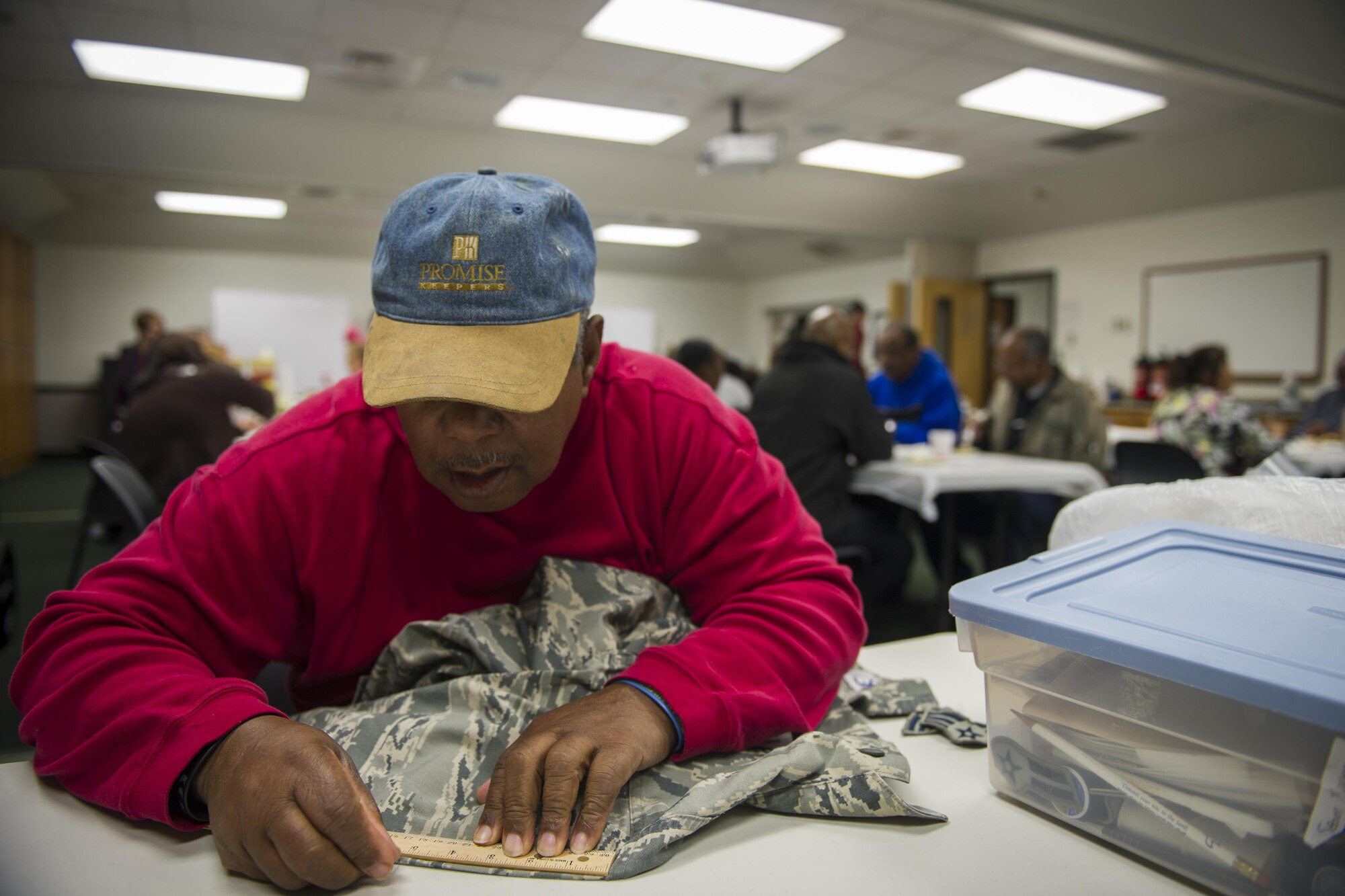 Jimmie Thomas, a Munch n’ Mend volunteer, measures the sleeve of an Airman battle uniform coat at Hurlburt Field, Fla., Jan. 9, 2016. Thomas has been volunteering with Munch ‘n Mend for more than 20 years. Munch n’ Mend is a free monthly event where Air Commandos of all rank, enlisted and officer, can take their uniforms to get rank, badges, name and Air Force tapes sewn on while enjoying a hot meal. (U.S. Air Force photo by Airman 1st Class Joseph Pick)