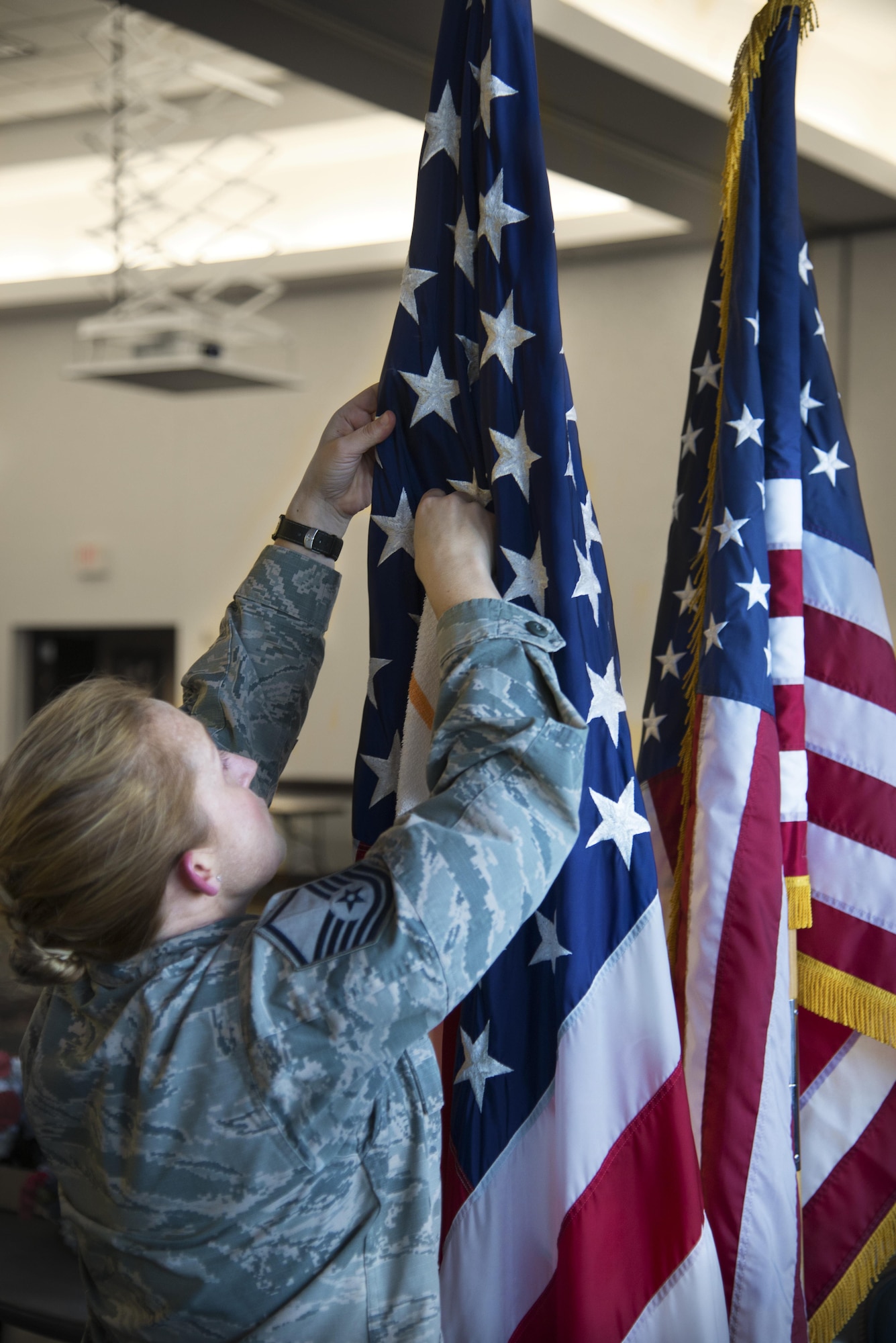 Master Sgt. Brenda Roskum, 375th Medical Operations Squadron, sets up flags for Scott Air Force Base’s Centennial Celebration Kick off, Jan.6, 2017, at the Scott Event Center. Special guest, Illinois Governor Bruce Rauner, joined in the festivities with a proclamation making 2017 the “Year of Scott AFB” for the state. (U.S. Air Force photo by Airman 1st Class Gwendalyn Smith)