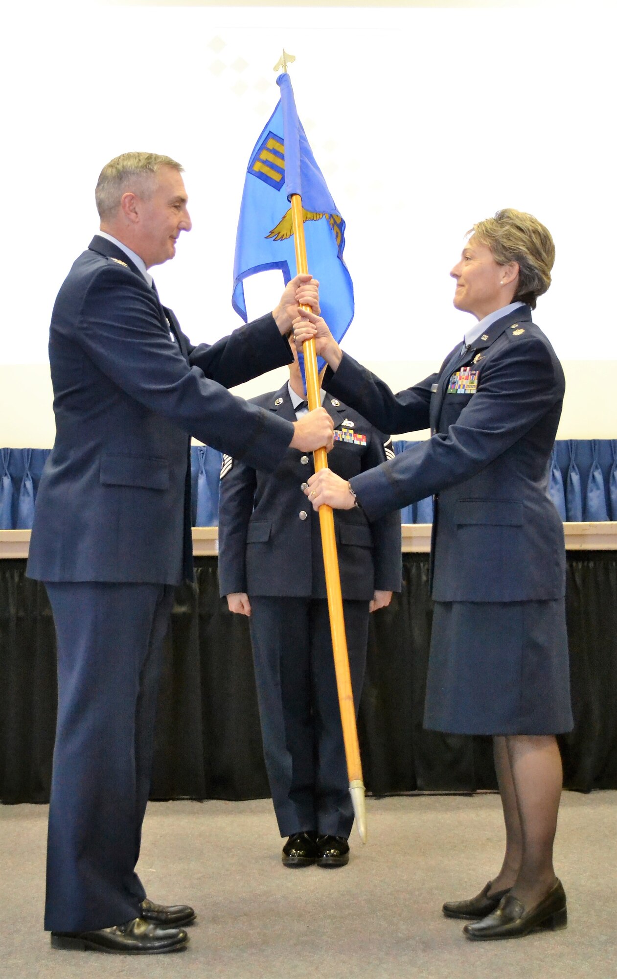 Commander of the 111th Attack Wing Howard Eissler hands the 111th Mission Support Group guidion to Lt. Col. Claudia Malone as she ceremoniously takes leadership of the group during an event held at Horsham Air Guard Station, Pa. Jan. 8, 2017. In addition to being the 111th MSG commander, Malone will also be commanding the newly-formed 112th Cyberspace Operations Squadron here. (U.S. Air National Guard photo by Tech. Sgt. Andria Allmond/ Released)