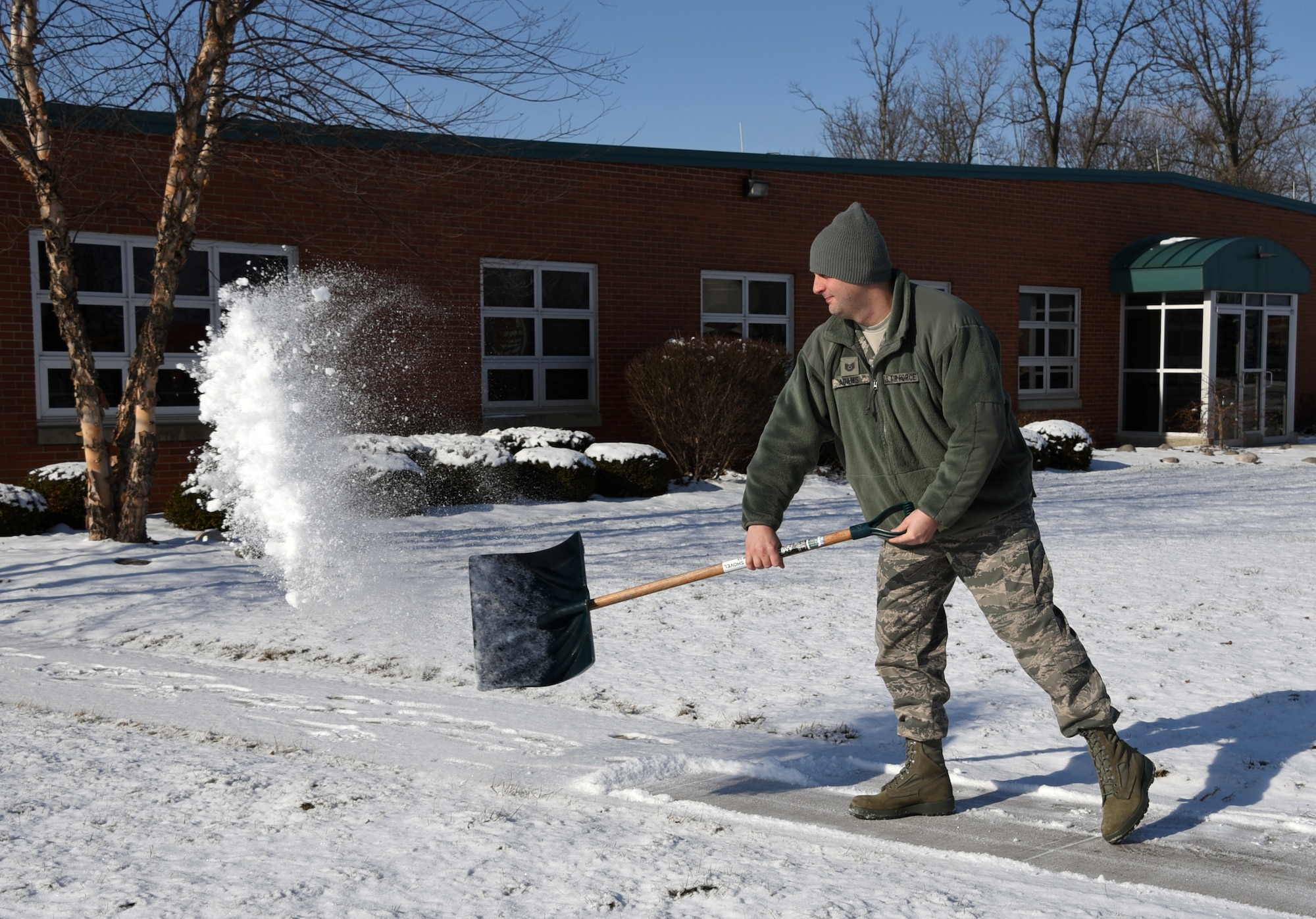 Tech. Sgt. Ray Adams, the occupational safety NCO of the 178th Wing, clears a sidewalk at the Springfield Air National Guard Base, Ohio Jan 7, 2017. The base safety office offers tips to help Airmen stay safe during inclement winter weather. (U.S. Air National Guard photo by Airman 1st Class Anthony Le)