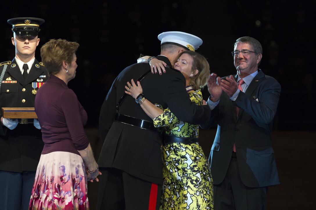 Marine Corps Gen. Joe Dunford, chairman of the Joint Chiefs of Staff, hugs Stephanie Carter, wife of Defense Secretary Ash Carter, right, after she received the Defense Department's Distinguished Public Service award during Carter's farewell ceremony at Joint Base Myer-Henderson Hall, Va., Jan. 9, 2016. DoD photo by EJ Hersom