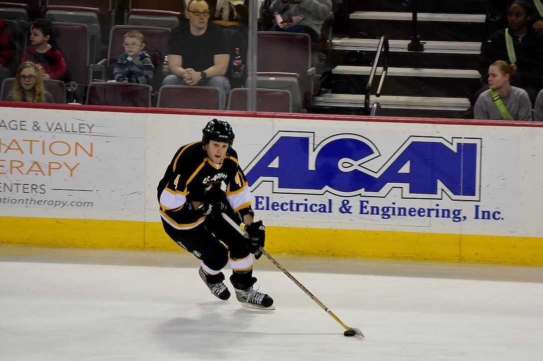 Army Cpl. Evan Hammersley moves the puck in the first period during the 4th Annual Army vs. Air Force Hockey game at the Sullivan Arena in Anchorage, Alaska, Jan. 7, 2017. Hammersley's 18 years of hockey experience helped in the Army's 5-0 shutout of the Air Force team. The series is now tied at two games each. Army photo by John Pennell