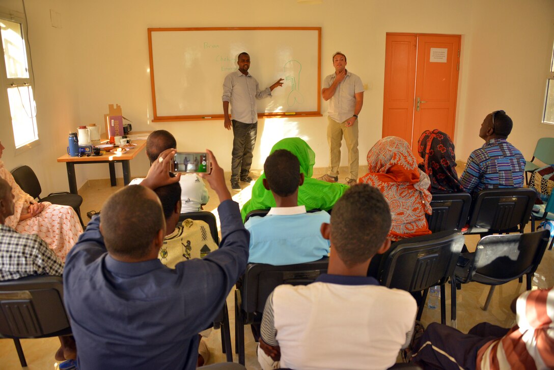 SOS Village D’ Enfants – Tadjoura administrators, staff members, and caretakers record footage and listen to a discussion on airway blockage given by Sgt. Brian Duckworth, a civil affairs team medic with C/Co 411th Civil Affairs Battalion, here on January 3, 2017. The SOS Village provides cares for 90 Djiboutian children at its compound and partnered with a local civil affairs team to hold discussions in shared best practices related to administering first aid.                                                                                                                  (US Army Photo By: Staff Sgt. Gregory Williams C Co/411th Civil Affairs Battalion)