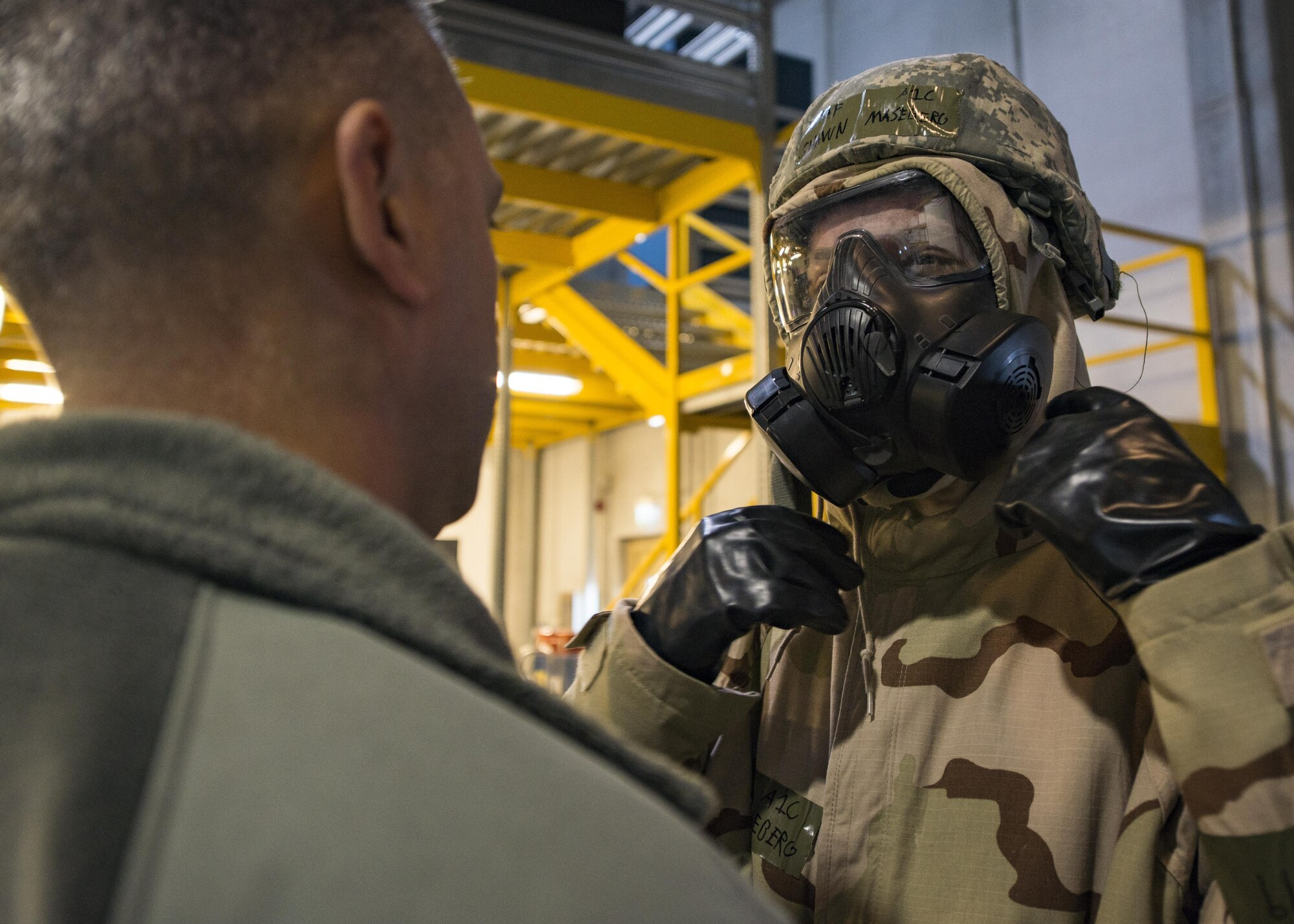 Master Sgt. James DeBiase, 31st Civil Engineer Squadron Emergency Response Operations section chief, observes Airman 1st Class Shawn Maseberg, 31st Munitions Squadron Precision Guided Munitions crewmember, donning his mission-oriented protective postures gear at Aviano Air Base, Italy on Jan. 6, 2017. Maseberg attended an Expeditionary Skills Rodeo event which condensed 16 hours of training into 6.6 hours. (U.S. Air Force photo by Senior Airman Cory W. Bush)