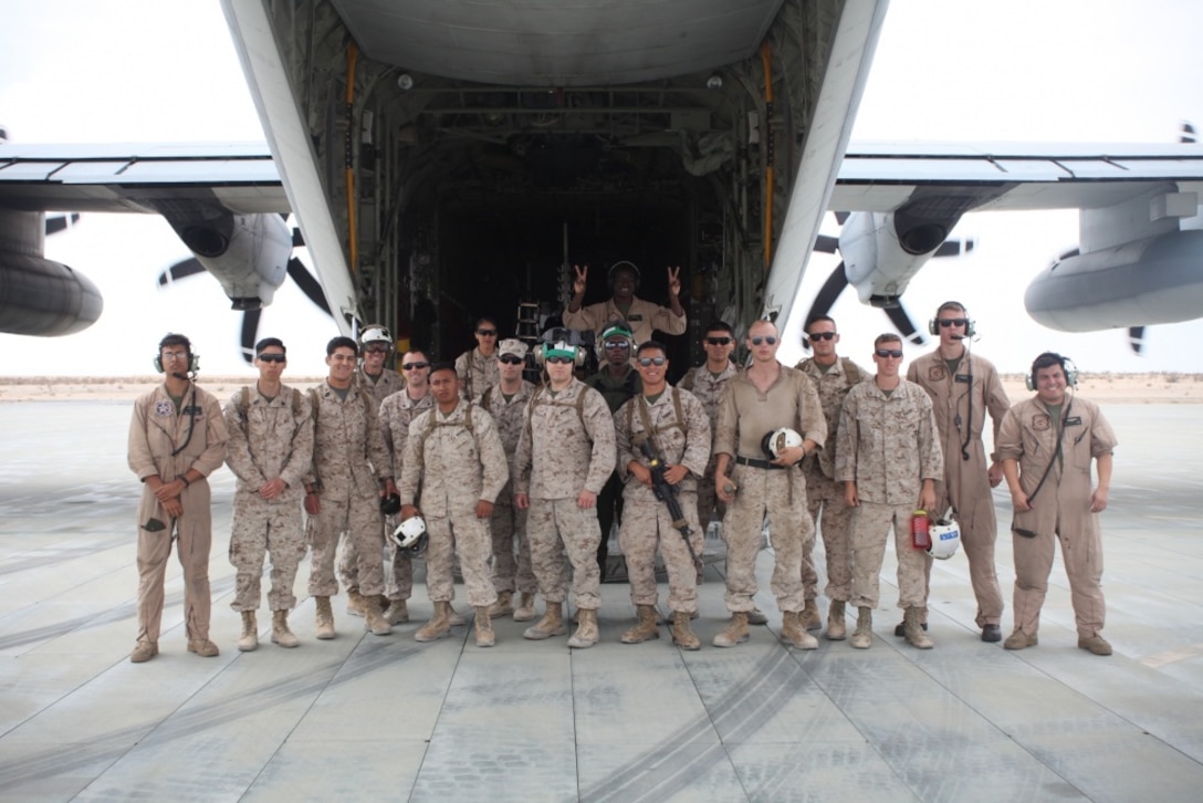 MARINE GROUND AIR COMBAT CENTER TWENTYNINE PALMS, CALIF., -- Marine Aircraft Group 41 Marines and sailors and Marine Aerial Refueler Transport Squadron 234 pose for a group photo outside a C-130 after a morale flight aboard Marine Ground Air Combat Center Twentynine Palms, Calif., June 21, 2016. The morale flight was an invitation extended to MAG-41 to view an aerial refueling of two F/A-18 jets.