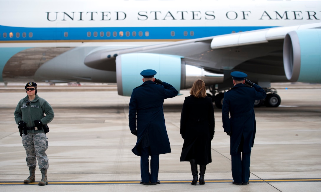 Col. Christopher Thompson (center), 89th Airlift Wing vice commander, his wife (center right), Shannon, and Tech. Sgt. Brian Greene (right), Special Airlift Mission passenger services agent, stand at attention as Air Force One taxis with the president to the runway for takeoff at Joint Base Andrews, Md., Jan. 10, 2017. Staff Sgt. Heather Alred (left), 811th Security Forces Squadron detail chief, maintained a watchful eye on the perimeter of the flightline until the aircraft was airborne. (U.S. Air Force photo by Staff Sgt. Joe Yanik)