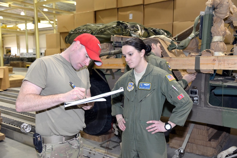 Army Staff Sgt. Christopher Allais, 151st Quartermaster Company Airdrop Load Inspector, and Air Force Staff Sgt. Casey Jackson, 43rd Operations Support Squadron Joint Airdrop Inspector, go over Jackson's notes before signing off on a palletized Humvee Jan. 6, 2017. Army and Air Force inspectors work together to make sure that regulations from both branches are met before loading cargo onto an Air Force aircraft. (U.S. Air Force photo by Master Sgt. Thomas J. Doscher/released)