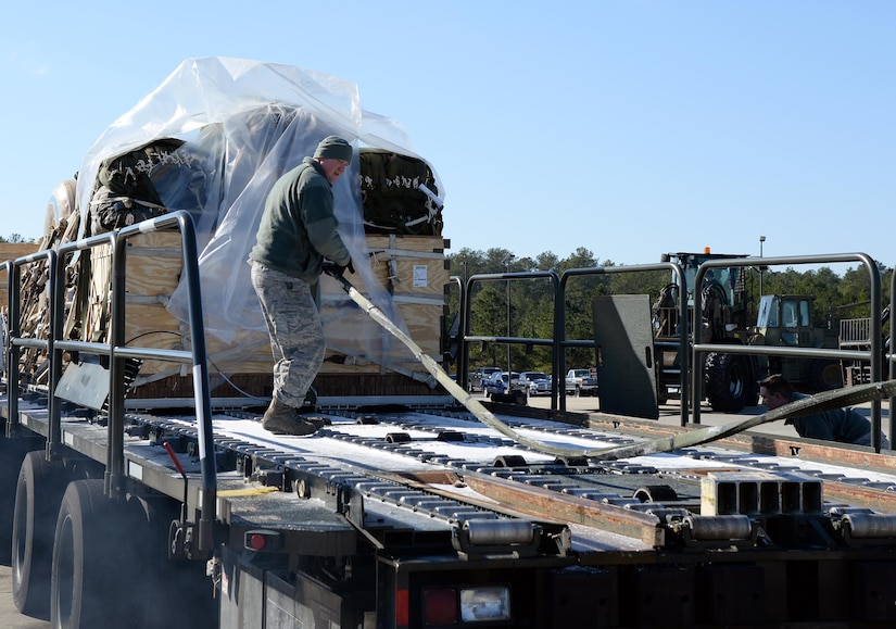 Tech. Sgt. Joshua Gaines, 43rd Air Mobility Squadron shift supervisor, checks a tow strap before loading cargo onto a K Loader during a Deployment Readiness Exercise on Pope Army Airfield Jan. 8, 2017. Cold weather had frozen stiff the rollers on the K Loader, requiring 43rd AMS porters to pull the cargo onto the loader with a forklift. (U.S. Air Force photo by Master Sgt. Thomas J. Doscher/released)