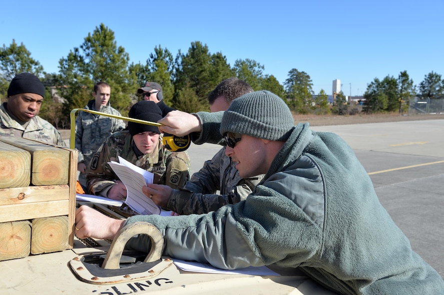 Senior Airman Joshua Slagel, a 43rd Air Mobility Squadron Joint Inspector, measures the shoring on a Humvee during a load inspection at the Arrival/Departure Airfield Control Group during a Deployment Readiness Exercise on Pope Army Airfield Jan. 9, 2017. Inspectors from the 43rd AMS act as a safety net to make sure cargo is properly prepared to be loaded onto Air Force aircraft. Improperly loaded cargo could be damaged or destroyed during an air drop. (U.S. Air Force photo/Master Sgt. Thomas J. Doscher)