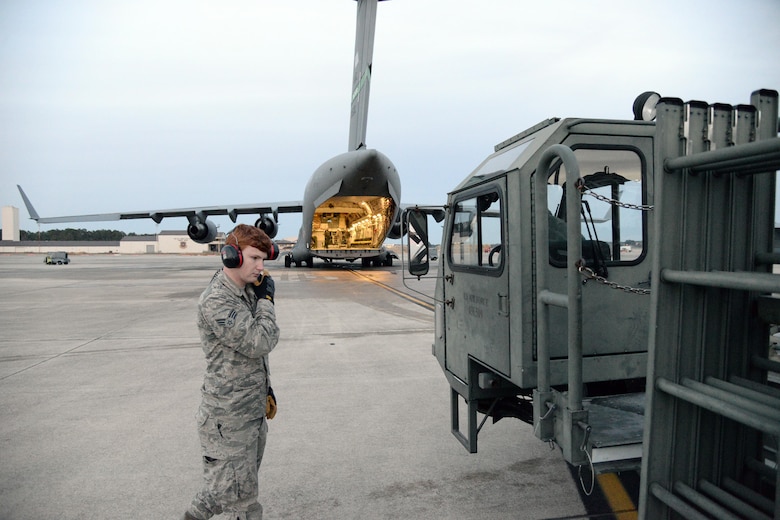 Senior Airman Tyler Long, 43rd Air Mobility Squadron Air Mobility Command Center controller, listens for updates during a Deployment Readiness Exercise on Pope Army Airfield Jan. 9, 2017. Two C-17 Globemaster IIIs facilitated static load training during the DRE, allowing the 43rd Air Mobility Operations Group to test how they prepare and ship cargo for deployment. (U.S. Air Force photo by Master Sgt. Thomas J. Doscher/released)