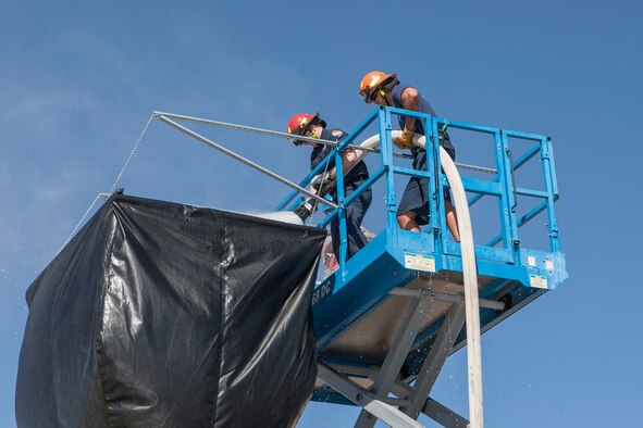 Edwards Air Force Base Fire Department fire fighters spray water down a prototype funnel in May 2016. Officials said the funnel needed a way for them to observe the water flowing inside so plastic windows were installed on the actual test funnels. (Courtesy photo by Tom Reynolds/Lockheed Martin) 