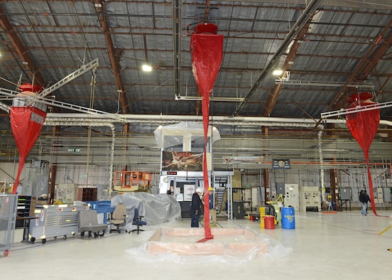 Red plastic funnels were affixed to ten fire suppression foam dispensers in Hangar 1820’s west side to conduct a test of the fire suppression system Jan. 8. Base civil engineers and the Edwards Air Force Base Fire Department used water to test the dispensers, which funneled down to a makeshift containment pool. Using this new funnel test system saved the base $79,750 according to the testers. (U.S. Air Force photo by Kenji Thuloweit)