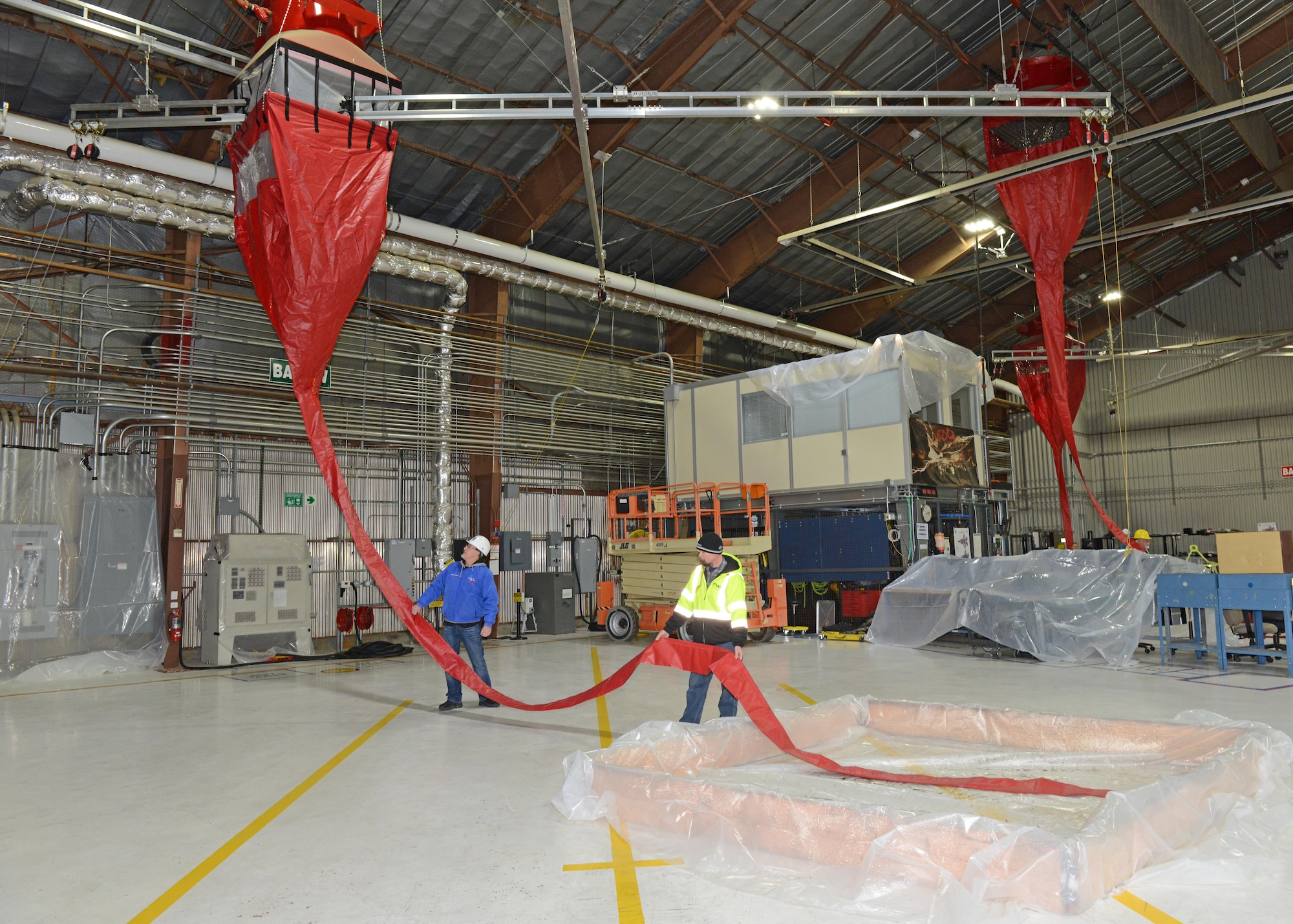 Containment pools (bottom right) were built with wood framing and plastic sheets to aid in water collection during the test. This is a different approach from previous tests where water or fire-fighting foam was released into the hangar after all equipment was manually covered up with plastic. (U.S. Air Force photo by Kenji Thuloweit)