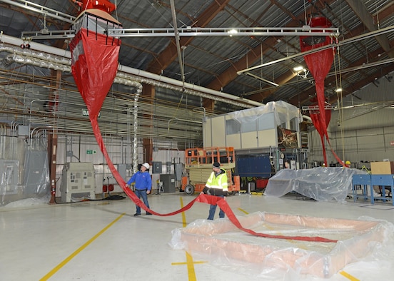 Containment pools (bottom right) were built with wood framing and plastic sheets to aid in water collection during the test. This is a different approach from previous tests where water or fire-fighting foam was released into the hangar after all equipment was manually covered up with plastic. (U.S. Air Force photo by Kenji Thuloweit)