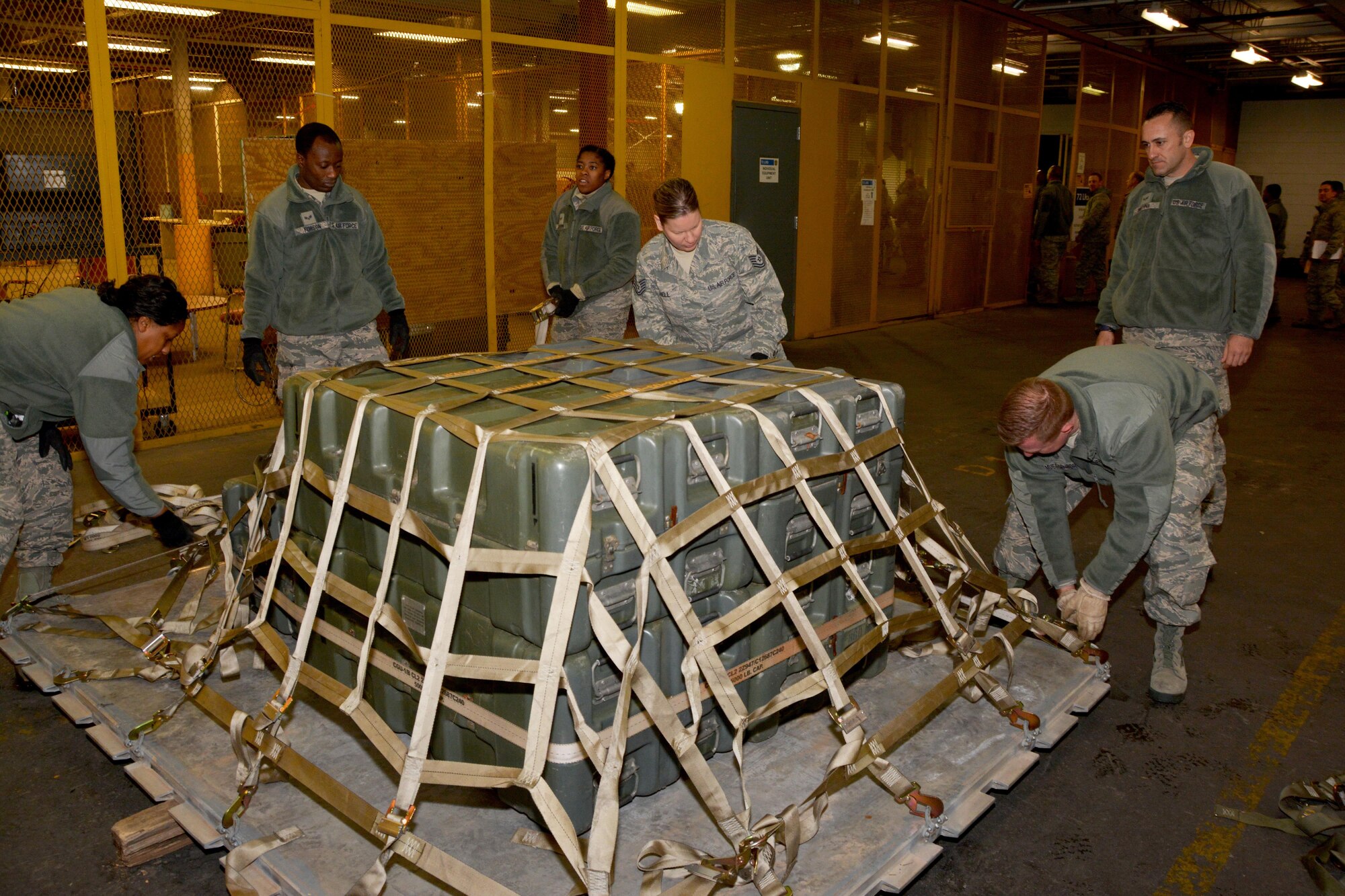 Members of the 507th Logistics Readiness Squadron secure cargo to a pallet in preparation for transport during a deployment exercise Jan. 8, 2017, at Tinker Air Force Base, Okla. Reservists with the 507th Air Refueling Wing participated in the exercise in preparation for the upcoming nuclear operational readiness inspection in March 2016. (U.S. Air Force photo/Tech Sgt. Lauren Gleason)