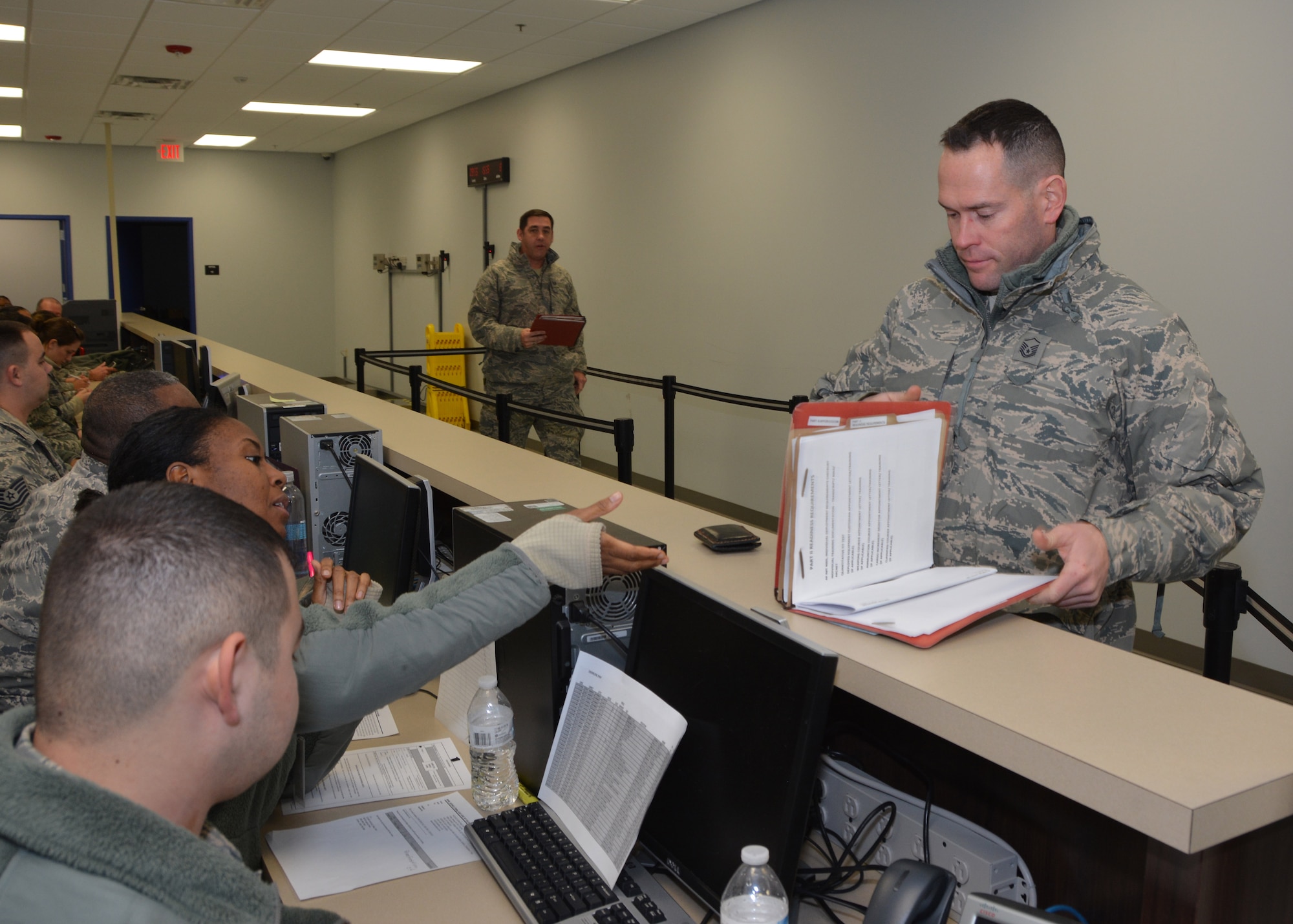 Master Sgt. Grady Epperly, photojournalist with 507th Air Refueling Wing Public Affairs, hands his deployment folder to Staff Sgt. Kallima Scott, force management technician with the 507th Force Support Squadron, during a deployment exercise Jan. 8, 2017, at Tinker Air Force Base, Okla. Reservists with the 507th Air Refueling Wing participated in the exercise in preparation for the upcoming nuclear operational readiness inspection in March 2016. (U.S. Air Force photo/Tech Sgt. Lauren Gleason)