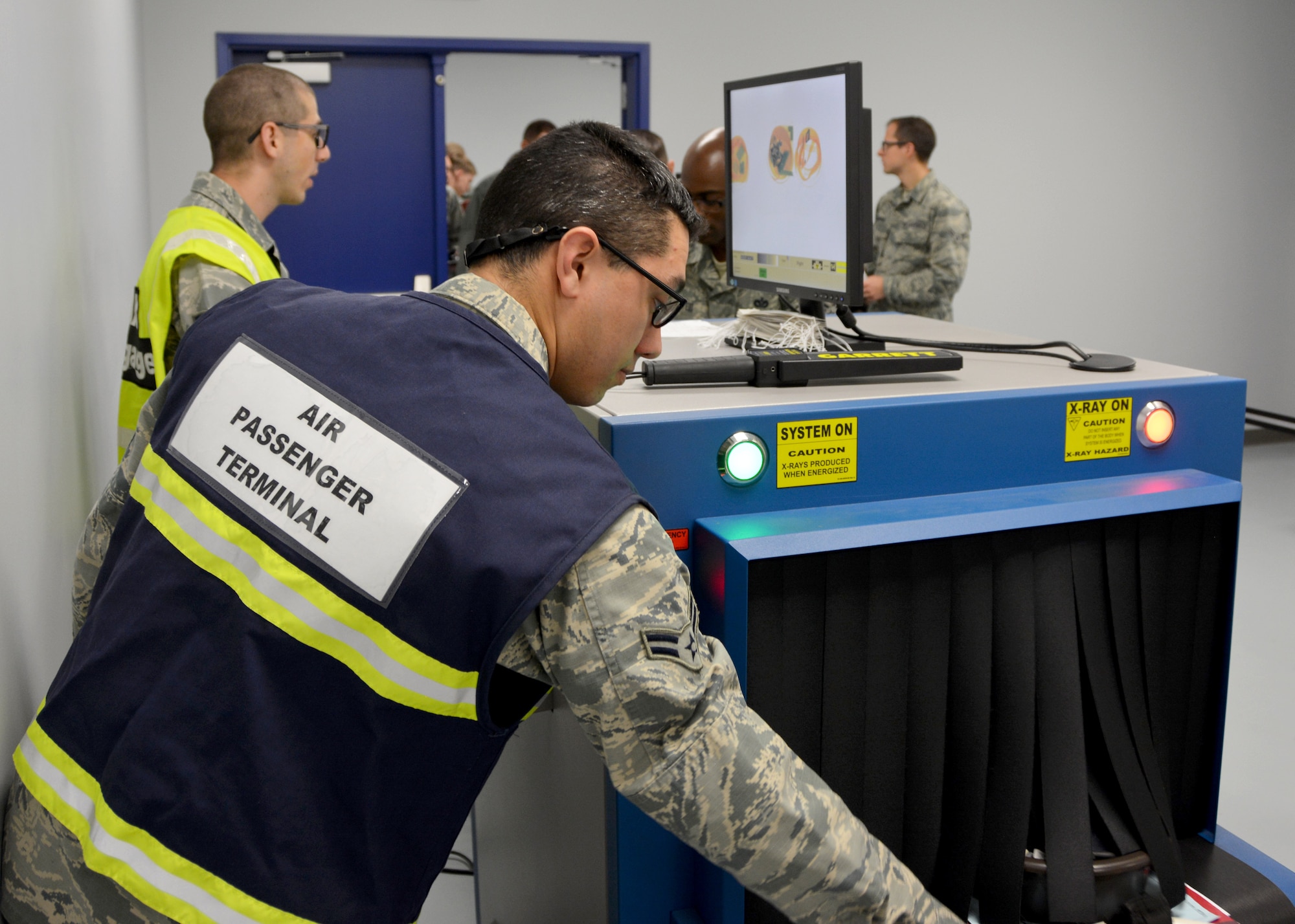 Senior Airman Ethan Griffith (on left), an air transportation journeyman with the 72nd Aerial Port Squadron, and Airman 1st Class Manuel Munoz, an aircraft service specialist with the 72nd Logistics Readiness Squadron, x-ray passenger’s carry-on items to ensure compliance with air safety regulations during a deployment exercise Jan. 8, 2017, at Tinker Air Force Base, Okla. Reservists participated in the exercise in preparation for the upcoming nuclear operational readiness inspection in March 2016. (U.S. Air Force photo/Tech Sgt. Lauren Gleason)