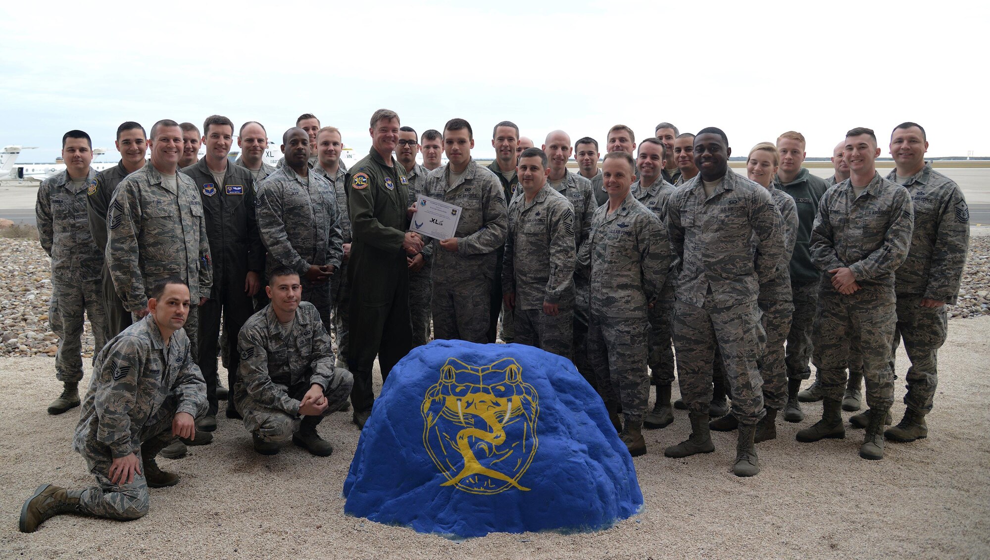 Senior Airman Luis Torres-Ortiz, 47th Operations Support Squadron aircrew flight equipment journeyman (front center), accepts the “XLer of the Week” award from Col. Thomas Shank, 47th Flying Training Wing commander (front left), and Chief Master Sgt. George Richey, 47th FTW command chief (front right), on Laughlin Air Force Base, Texas, Jan. 3, 2017. The XLer is a weekly award chosen by wing leadership and is presented to those who consistently make outstanding contributions to their unit and Laughlin. (U.S. Air Force photo/Senior Airman Ariel Partlow)