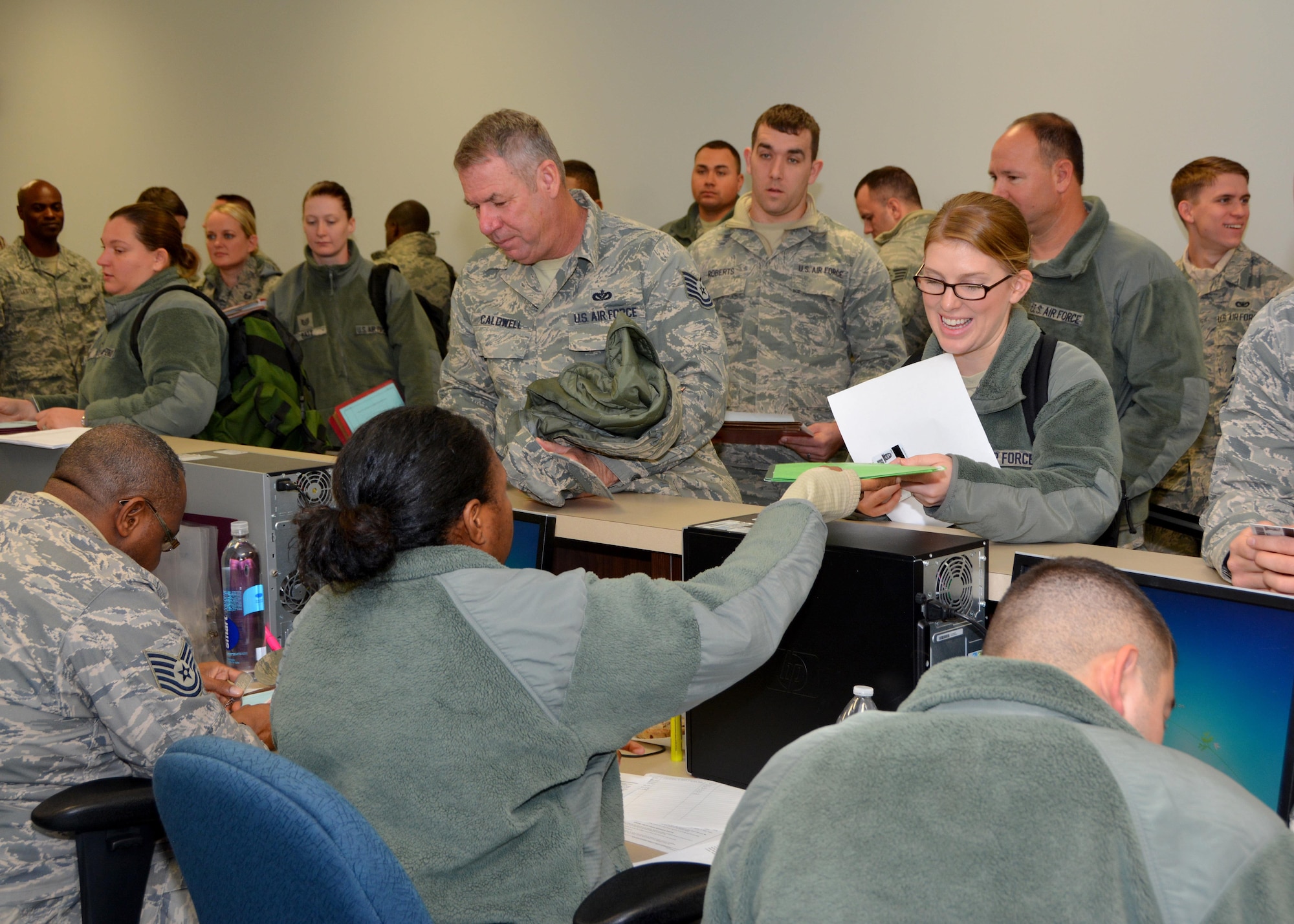 Tech. Sgt. Linda Ramirez of the 507th Medical Squadron hands her mobility paperwork to Staff Sgt. Kallima Scott, a force management technician with the 507th Force Support Squadron, during an exercise deployment processing line Jan. 8, 2017, at Tinker Air Force Base, Okla. The 507th FSS ensures Reservists have current emergency contact data and possession of their dog tags prior to deploying in preparation for the upcoming nuclear operational readiness inspection in March 2016. (U.S. Air Force photo/Tech Sgt. Lauren Gleason)