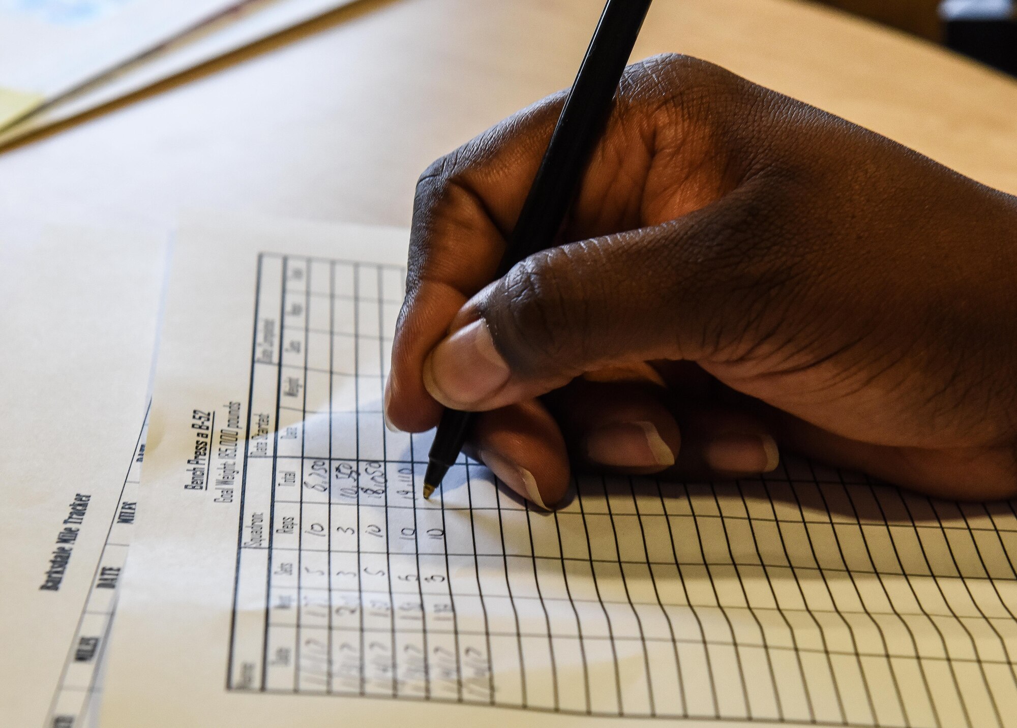 An Airman fills out a score chart for the Bench Press a B-52 challenge at Barksdale Air Force Base, La., Jan. 10, 2017. To complete the challenge, Airmen must bench press a combined total weight of 185,000 lbs. (U.S. Air Force photo/ Senior Airmen Luke Hill)