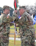 Command Sgt. Maj. Aaron Stone (left), incoming command sergeant major for the 187th Medical Battalion, accepts the guidon from Lt. Col. John Detro (center), while outgoing Command Sgt. Maj. Rakimm Broadnax-Rogers (right) looks on at the Army Medical Department Museum at Joint Base San Antonio-Fort Sam Houston Jan. 11
