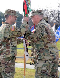 Command Sgt. Maj. Aaron Stone (left), incoming command sergeant major for the 187th Medical Battalion, accepts the guidon from Lt. Col. John Detro (center), while outgoing Command Sgt. Maj. Rakimm Broadnax-Rogers (right) looks on at the Army Medical Department Museum at Joint Base San Antonio-Fort Sam Houston Jan. 11
