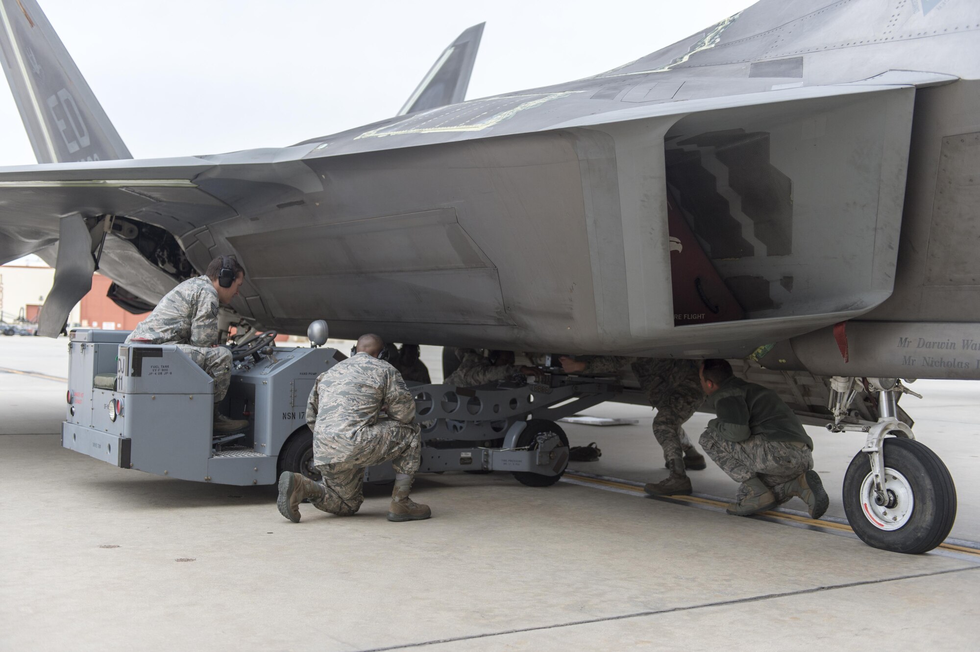 Members of the 411th Aircraft Maintenance Unit load a GBU-32 with a jammer into an F-22 Raptor's internal weapons bay Jan. 3. (U.S. Air Force photo by Kyle Larson)