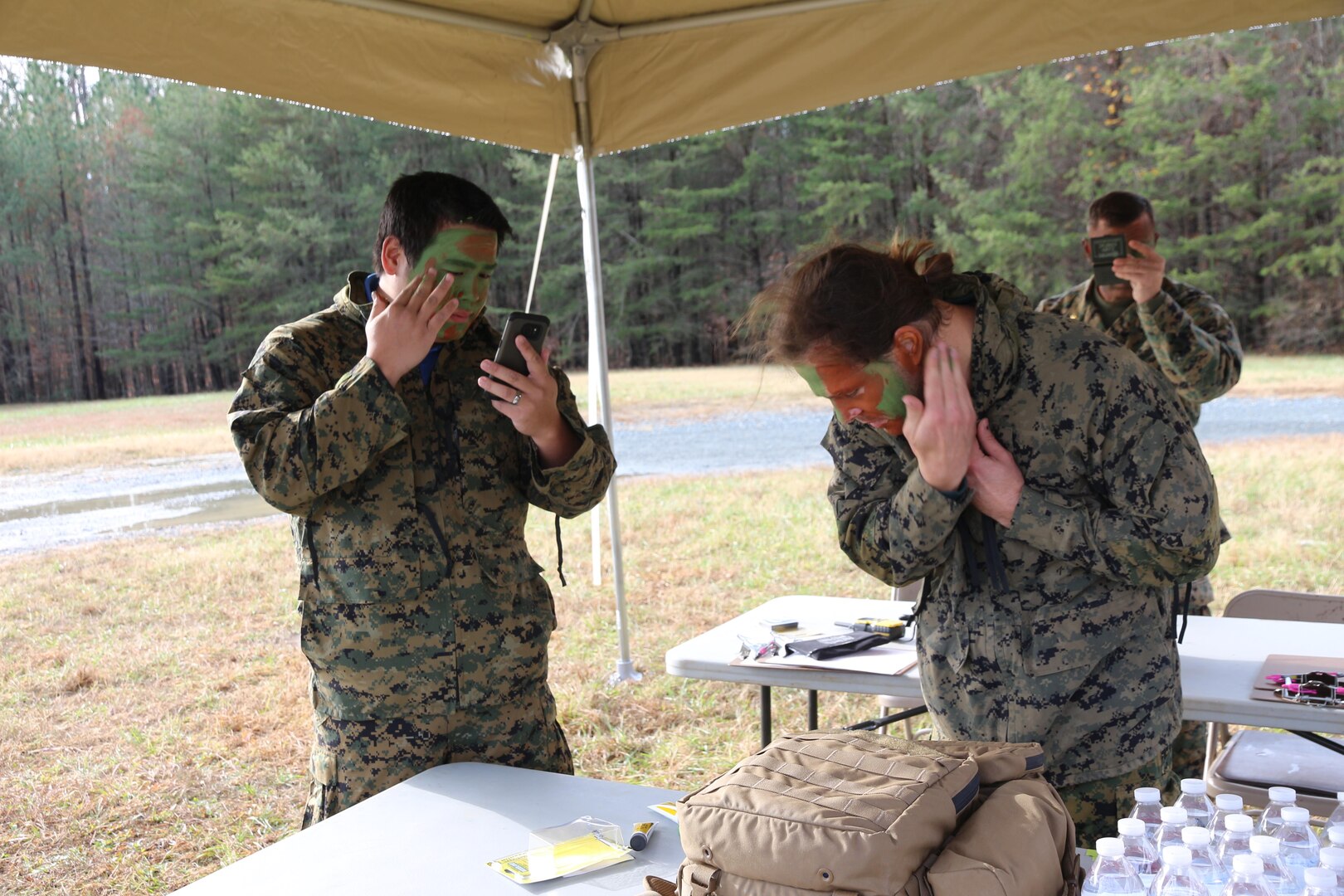 Evan Luo and Justin Miller, engineers from Marine Corps Systems Command’s Marine Expeditionary Rifle Squad team, apply camouflage paint as part of a target detection evaluation in December aboard Marine Corps Base Quantico, Va. MCSC engineers conducted target detection speed trials with combat instructors from the School of Infantry–East to evaluate how fast the instructors could detect the decoys, who were outfitted in varying camouflage gear. The evaluation was part of the Infantry Equipping Challenge, an ongoing effort at Marine Corps Systems Command to leverage new and emerging technologies from industry to enhance the capability of Infantry Marines. (U.S. Marine Corps photo by Ashley Calingo)