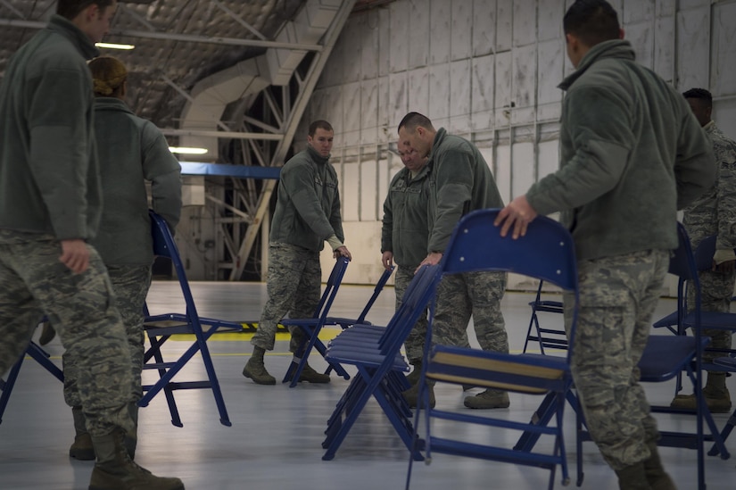 Airmen with the 11th Civil Engineer Squadron organize chairs for the farewell ceremony for Secretary of the Air Force Deborah Lee James at Joint Base Andrews, Md., Jan. 11, 2017. Approximately 200 Airmen with the 11th Wing assisted with setting up chairs, bleachers and more. (U.S. Air Force photo by Senior Airman Mariah Haddenham)