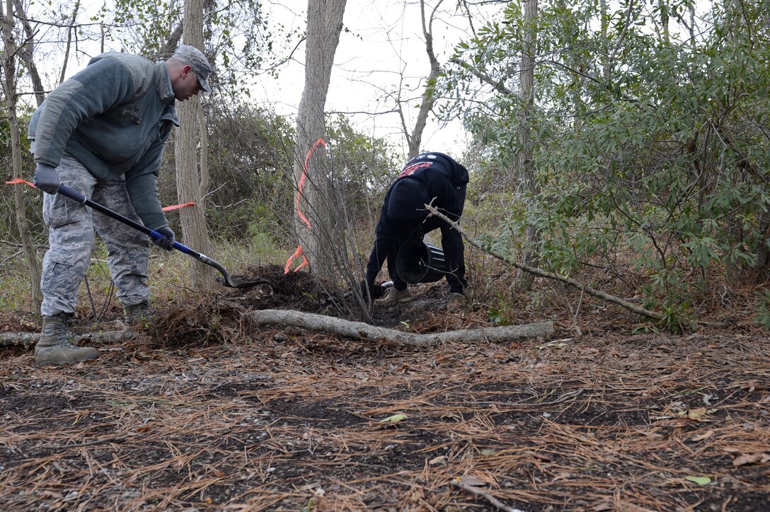 U.S. Air Force Staff Sgt. Josh Formanek and Airman 1st Class Cody Martin, 633rd Communication Squadron client system technicians, relocate a pollinating tree from the Bethel Park Garden to the nature trail during a volunteer event at Joint Base Langley-Eustis, Va., Jan. 6, 2017. Pollinator plants will increase the biodiversity within the nature trail by attracting a wider range of animal species. (U.S. Air Force photo by Airman 1st Class Kaylee Dubois)