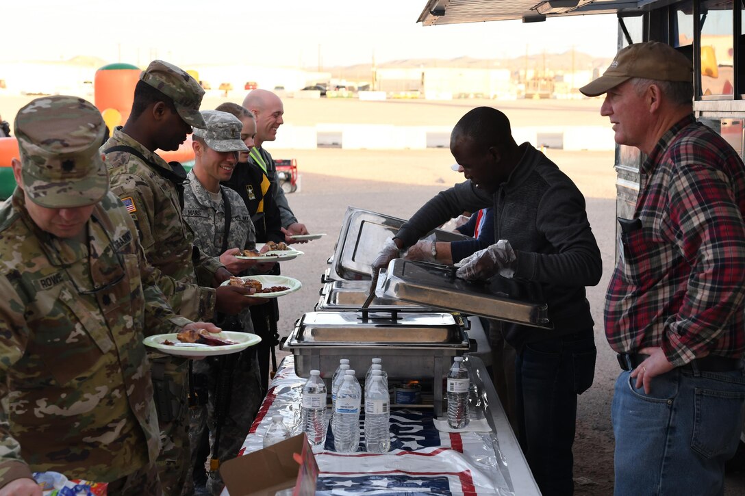 USO volunteers serve Soldiers during “Party in the Desert,” an event with the 642nd Regional Support Group, at McGregor Range, N.M., Dec. 12, 2016. 