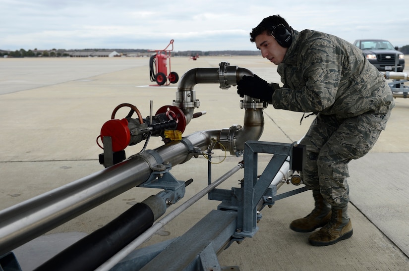 U.S. Air Force Airman Anthony Sanchez, 733rd Logistics Readiness Squadron fuels distribution operator, moves a fuel line in place during a hot pit refuel at Joint Base Langley-Eustis, Va., Jan. 6, 2017. Hot pits which can be done in less than 20 minutes, allowing aircraft to quickly launch after refueling. (U.S. Air Force photo by Airman 1st Class Kaylee Dubois)