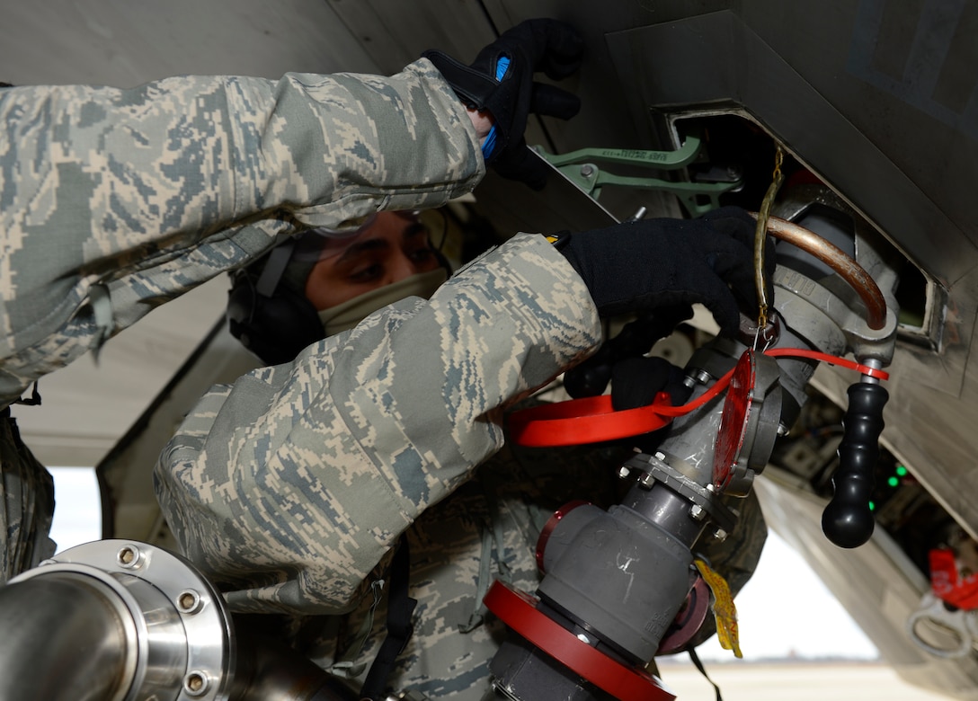 A U.S. Air Force 1st Aircraft Maintenance Squadron crew chief tightens the fuel line nozzle to the F-22 Raptor’s fuel tank during a hot pit refuel at Joint Base Langley-Eustis, Va., Jan. 6, 2017. Hot pits are performed while the engine of the plane is running to allow aircraft to launch quickly after refueling. (U.S. Air Force photo by Airman 1st Class Kaylee Dubois)