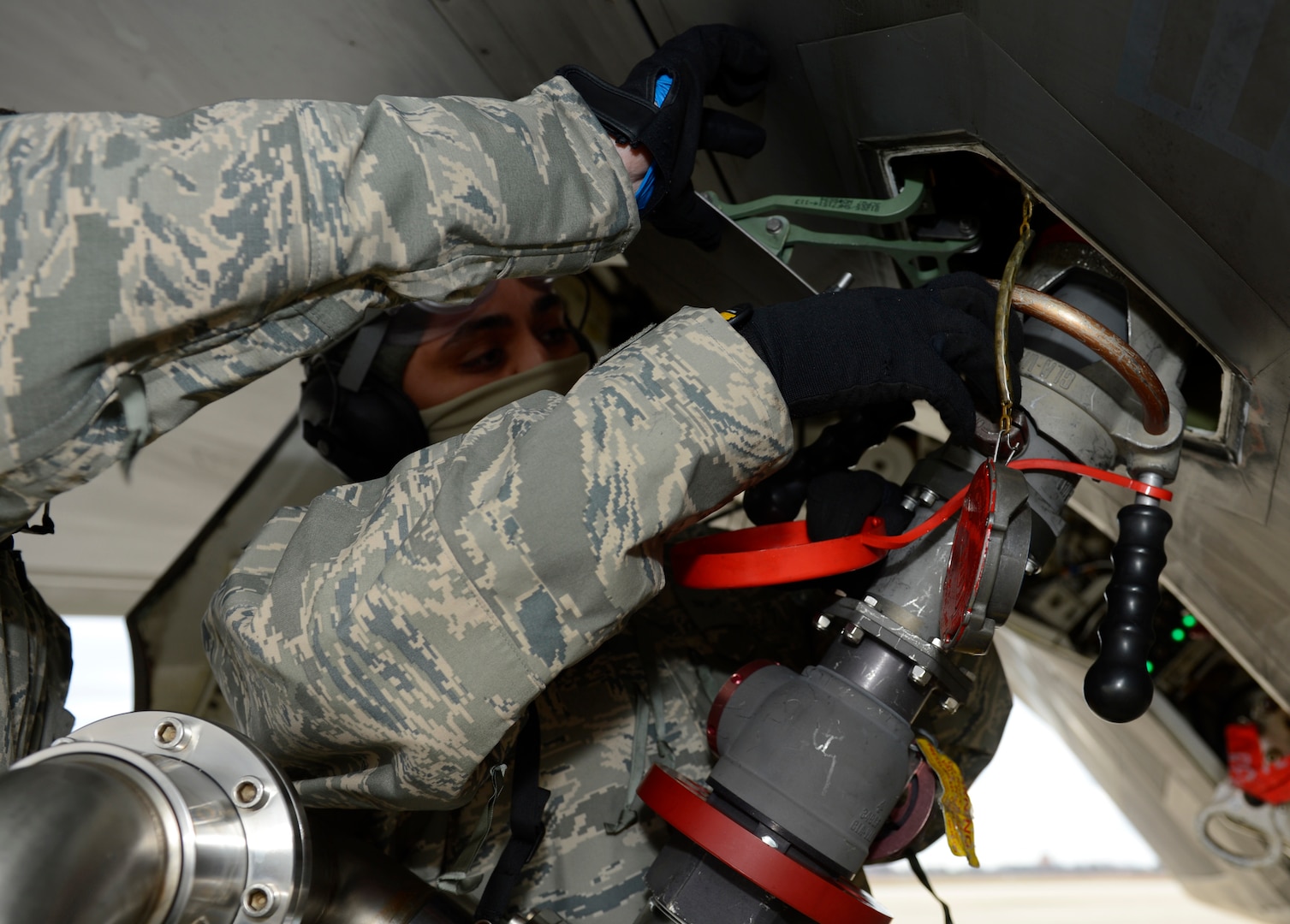 A U.S. Air Force 1st Aircraft Maintenance Squadron crew chief tightens the fuel line nozzle to the F-22 Raptor’s fuel tank during a hot pit refuel at Joint Base Langley-Eustis, Va., Jan. 6, 2017. Hot pits are performed while the engine of the plane is running to allow aircraft to launch quickly after refueling. (U.S. Air Force photo by Airman 1st Class Kaylee Dubois)