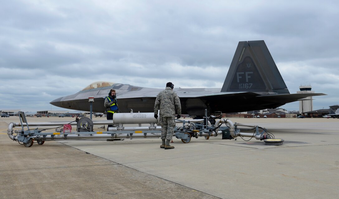 U.S. Air Force Airman Anthony Sanchez, 733rd Logistics Readiness Squadron fuels distribution operator, works with 1st Fighter Wing crew chiefs to refuel an F-22 Raptor during a hot pit refuel at Joint Base Langley-Eustis, Va., Jan. 6, 2017. Maintenance Airmen communicate with pilots while refueling aircraft to help gauge how much fuel is loaded. (U.S. Air Force photo by Airman 1st Class Kaylee Dubois)