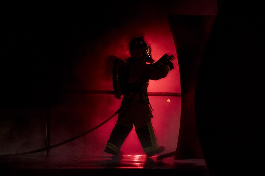 A firefighter enters a prop aircraft during nighttime, live-fire training, Jan. 10, 2017, at Moody Air Force Base, Ga. After extinguishing external fires, firefighters entered the prop aircraft to continue combating the flames inside. (U.S. Air Force photo by Airman 1st Class Daniel Snider)