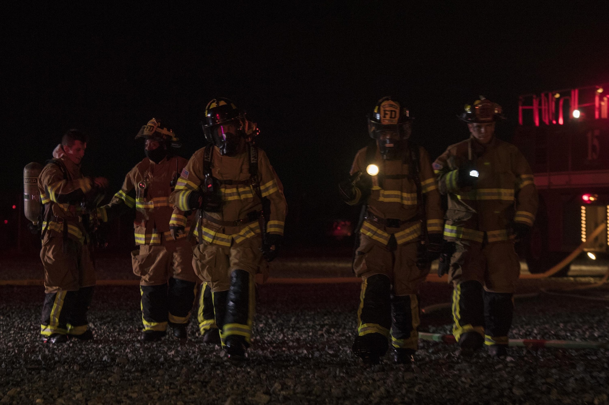 Firefighters from the 23d Civil Engineer Squadron begin to congregate after completing nighttime, live-fire training, Jan. 10, 2017, at Moody Air Force Base, Ga. It’s required by the Federal Aviation Administration that every airfield have a firefighting team on standby in case of an aircraft incident. (U.S. Air Force photo by Airman 1st Class Daniel Snider)
