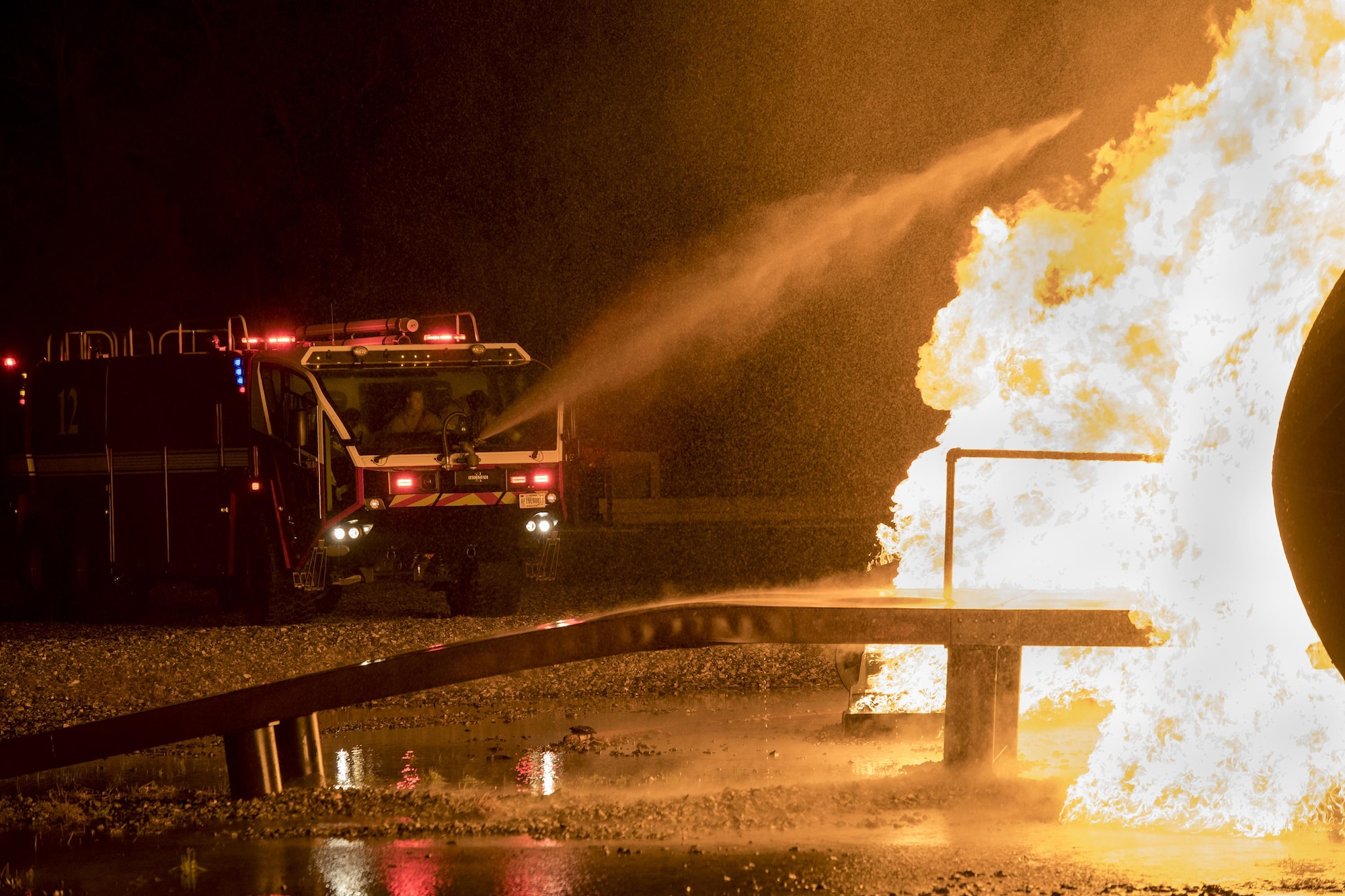 A P-23 Airport Rescue Fire Fighting vehicle drenches a prop aircraft during nighttime, live-fire training, Jan. 10, 2017, at Moody Air Force Base, Ga. The P-23 ARFF is capable of carrying up to 3,300 gallons of water, 500 gallons of fire-retardant foam and 500lbs of dry powder for extinguishing fires. (U.S. Air Force photo by Airman 1st Class Daniel Snider)