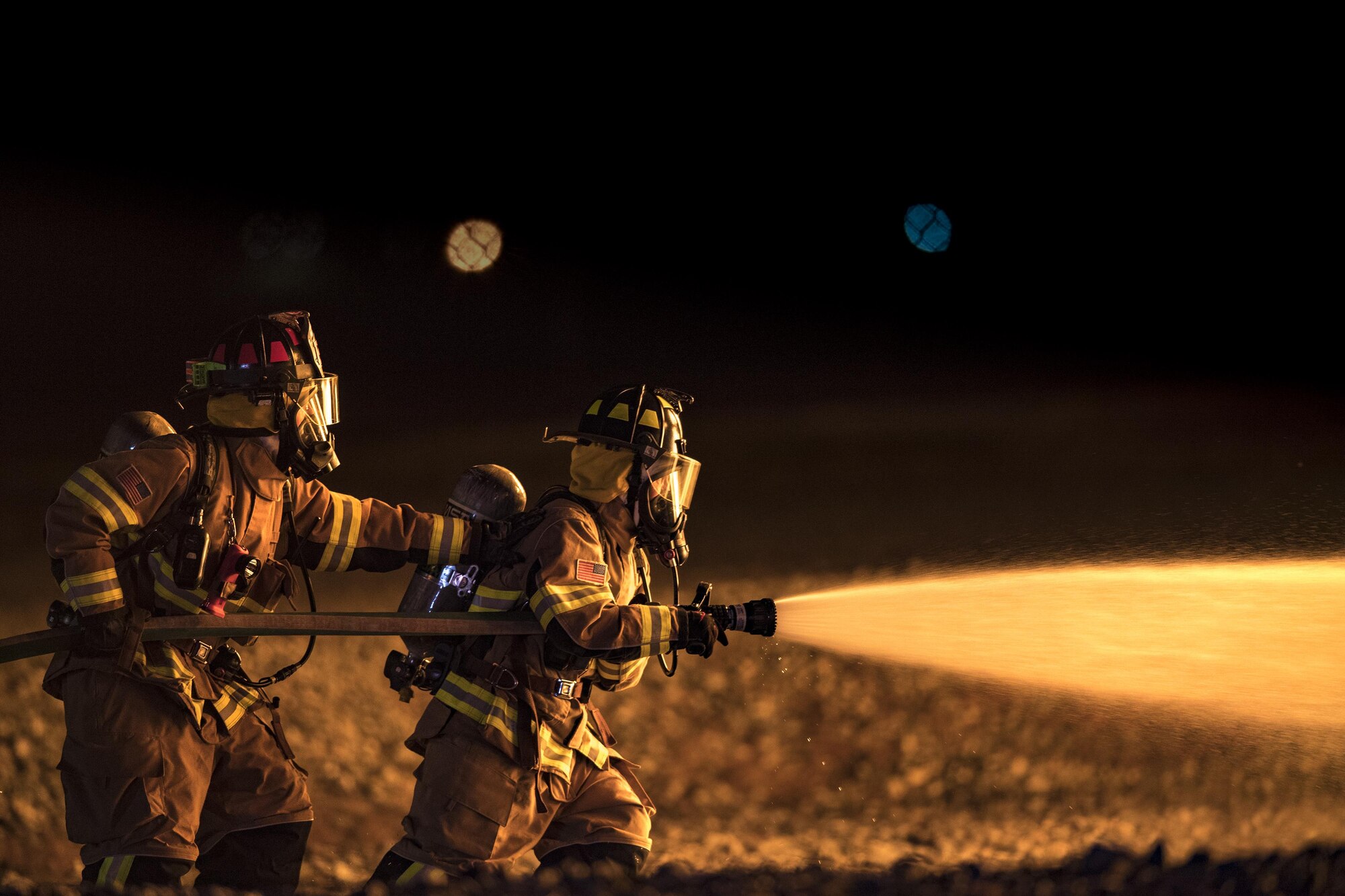 Firefighters from the 23d Civil Engineer Squadron advance towards a fire during nighttime, live-fire training, Jan. 10, 2017, at Moody Air Force Base, Ga. This training is an annual requirement for Moody firefighters and is just one of the ways they stay ready to protect people, property and the environment from fires and disasters. (U.S. Air Force photo by Staff Sgt. Ryan Callaghan)
