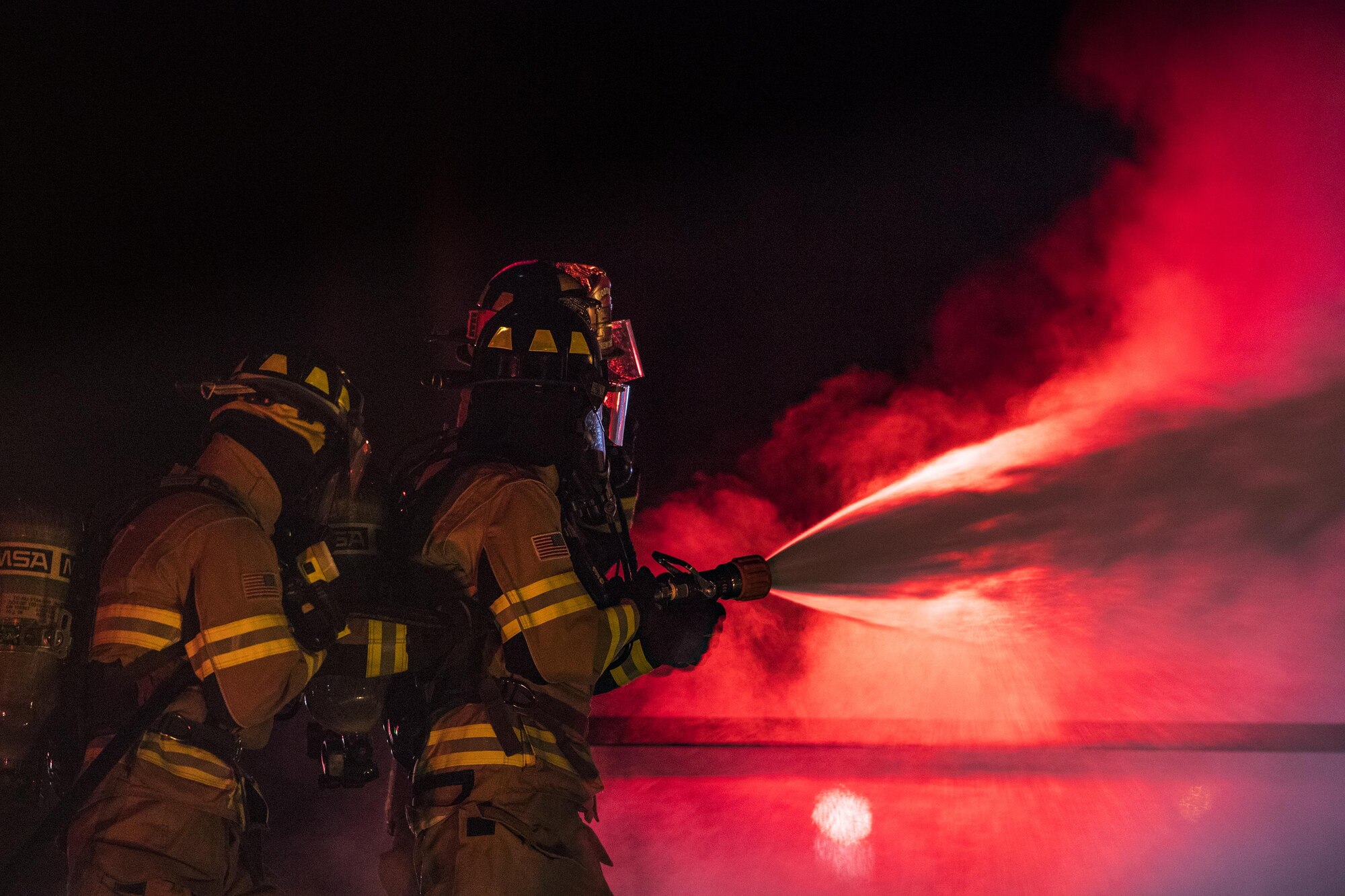 Firefighters from the 23d Civil Engineer Squadron douse a prop aircraft during nighttime, live-fire training, Jan. 10, 2017, at Moody Air Force Base, Ga. This training is an annual requirement for Moody firefighters and is just one of the ways they stay ready to protect people, property and the environment from fires and disasters. (U.S. Air Force photo by Staff Sgt. Ryan Callaghan)
