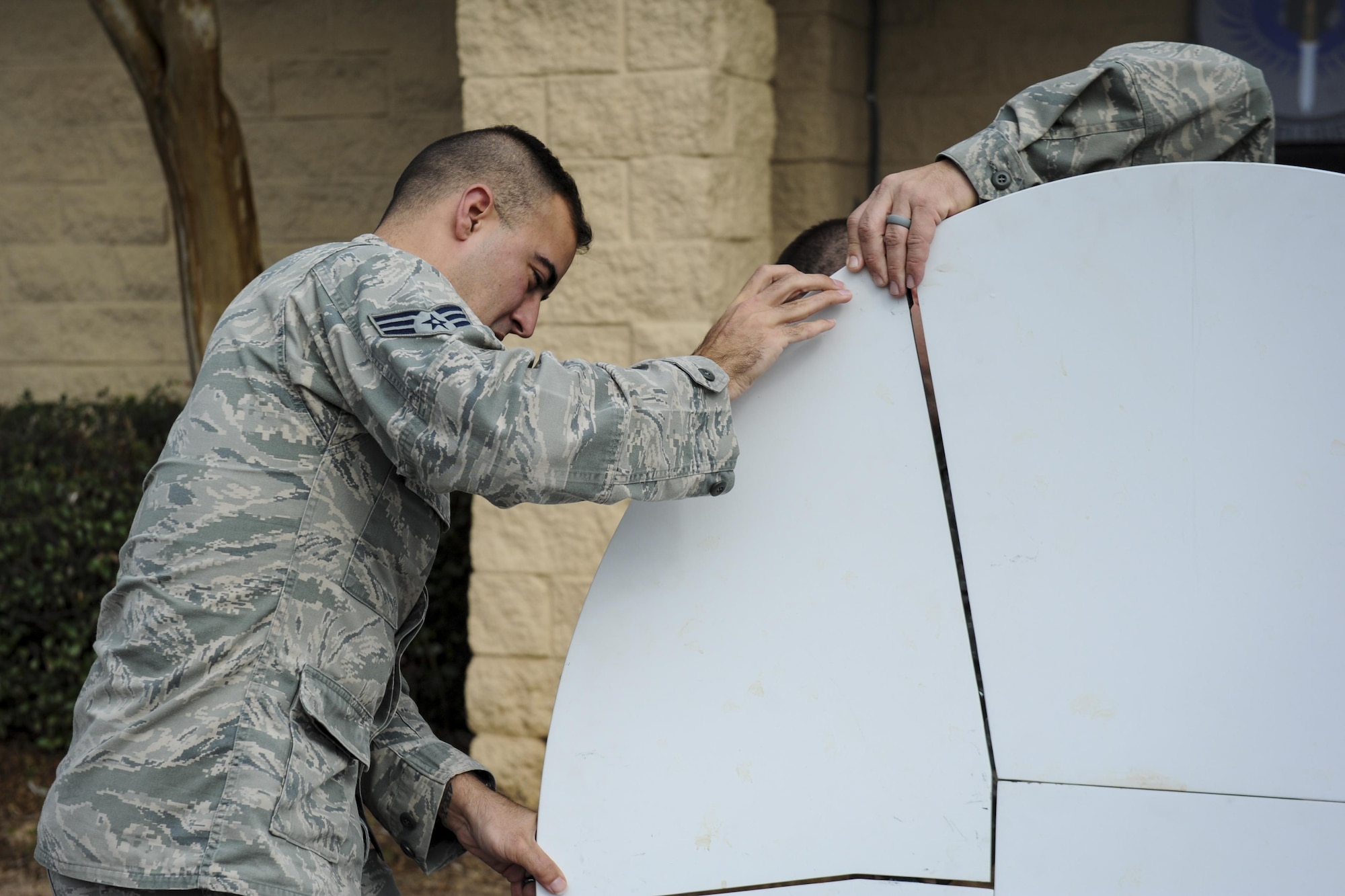Senior Airman Daniel Robertson, a client systems journeyman with the 25th Intelligence Squadron, assists in installing a Hawkeye lite satellite dish at Hurlburt Field, Fla., Jan. 11, 2017. These dishes are used to provide secured internet access in deployed locations to continue special operations missions. Anytime, anyplace. (U.S. Air Force photo by Airman Dennis Spain)