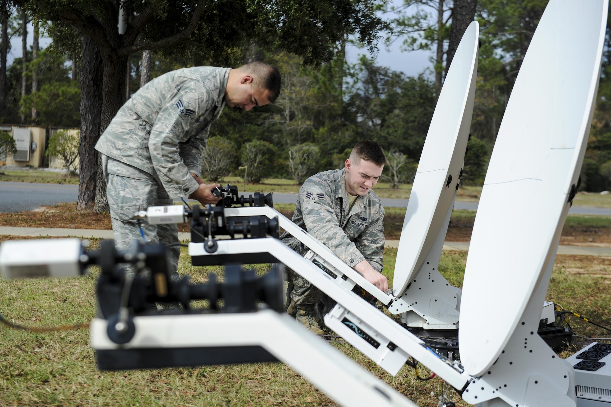 Senior Airman Daniel Robertson, left, a client systems journeyman with the 25th Intelligence Squadron, and Senior Airman Isaac Parent, a cyber transport journeyman with the 25 Intelligence Squadron install a Hawkeye lite satellite dish at Hurlburt Field, Fla., Jan. 11, 2017. These dishes are used to provide secured internet access in deployed locations to continue special operations missions. Anytime, anyplace. (U.S. Airman Dennis Spain)