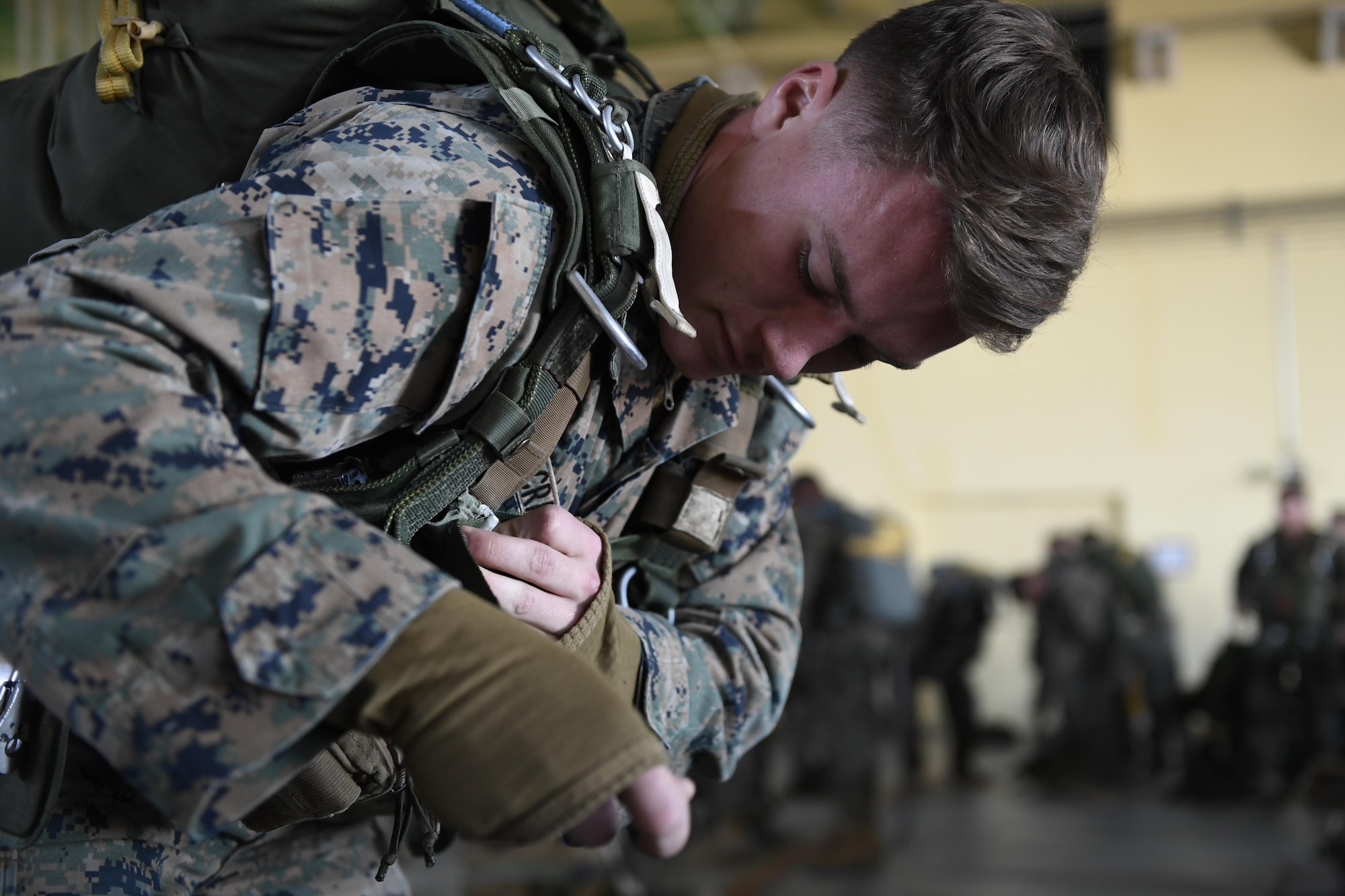 A Marine with the 3rd Reconnaissance Battalion, 3rd Marine Division, III Marine Expeditionary Force, straps a parachute to his body in preparation for a static line parachute drop on Jan. 11, 2017, at Yokota Air Base, Japan. The training ensures that jumpers and flight crew are ready to respond to real world events throughout the Indo-Asia Pacific region. (U.S. Air Force photo by Airman 1st Class Donald Hudson)