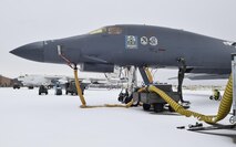 Yellow conditioned air hoses stretch from the underside of a B-1B Lancer to a large heating unit as maintenance work on the aircraft continues despite the rare accumulation of snow at the Oklahoma City Air Logistics Complex Jan. 6, 2017, Tinker Air Force Base, Oklahoma. Significant snowfall occurred overnight and in the early morning hours of Jan. 6th in the Oklahoma City region, but did not halt maintenance operations at the sprawling base. (U.S. Air Force photo/Greg L. Davis)