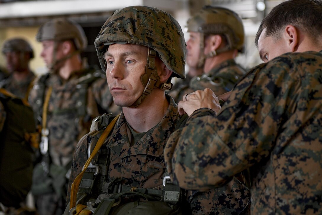 A Marine with the 3rd Reconnaissance Battalion, 3rd Marine Division, III Marine Expeditionary Force, waits while the jump master performs an equipment inspection in preparation for a static line parachute drop on Jan. 11, 2017, at Yokota Air Base, Japan. The training ensures that jumpers and flight crew are ready to respond to real world events throughout the Indo-Asia Pacific region. (U.S. Air Force photo by Airman 1st Class Donald Hudson)