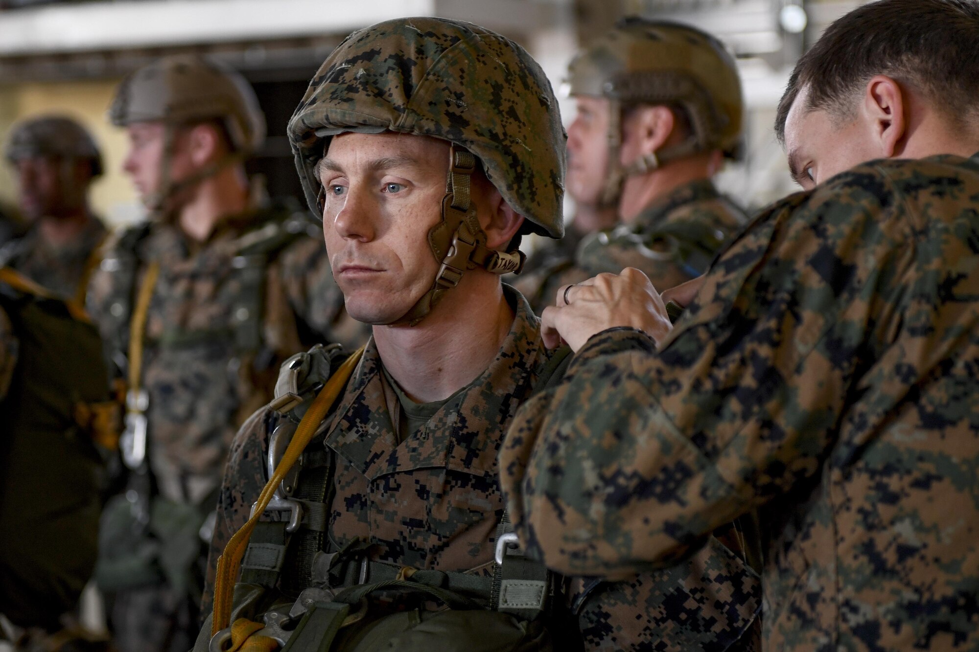 A Marine with the 3rd Reconnaissance Battalion, 3rd Marine Division, III Marine Expeditionary Force, waits while the jump master performs an equipment inspection in preparation for a static line parachute drop on Jan. 11, 2017, at Yokota Air Base, Japan. The training ensures that jumpers and flight crew are ready to respond to real world events throughout the Indo-Asia Pacific region. (U.S. Air Force photo by Airman 1st Class Donald Hudson)