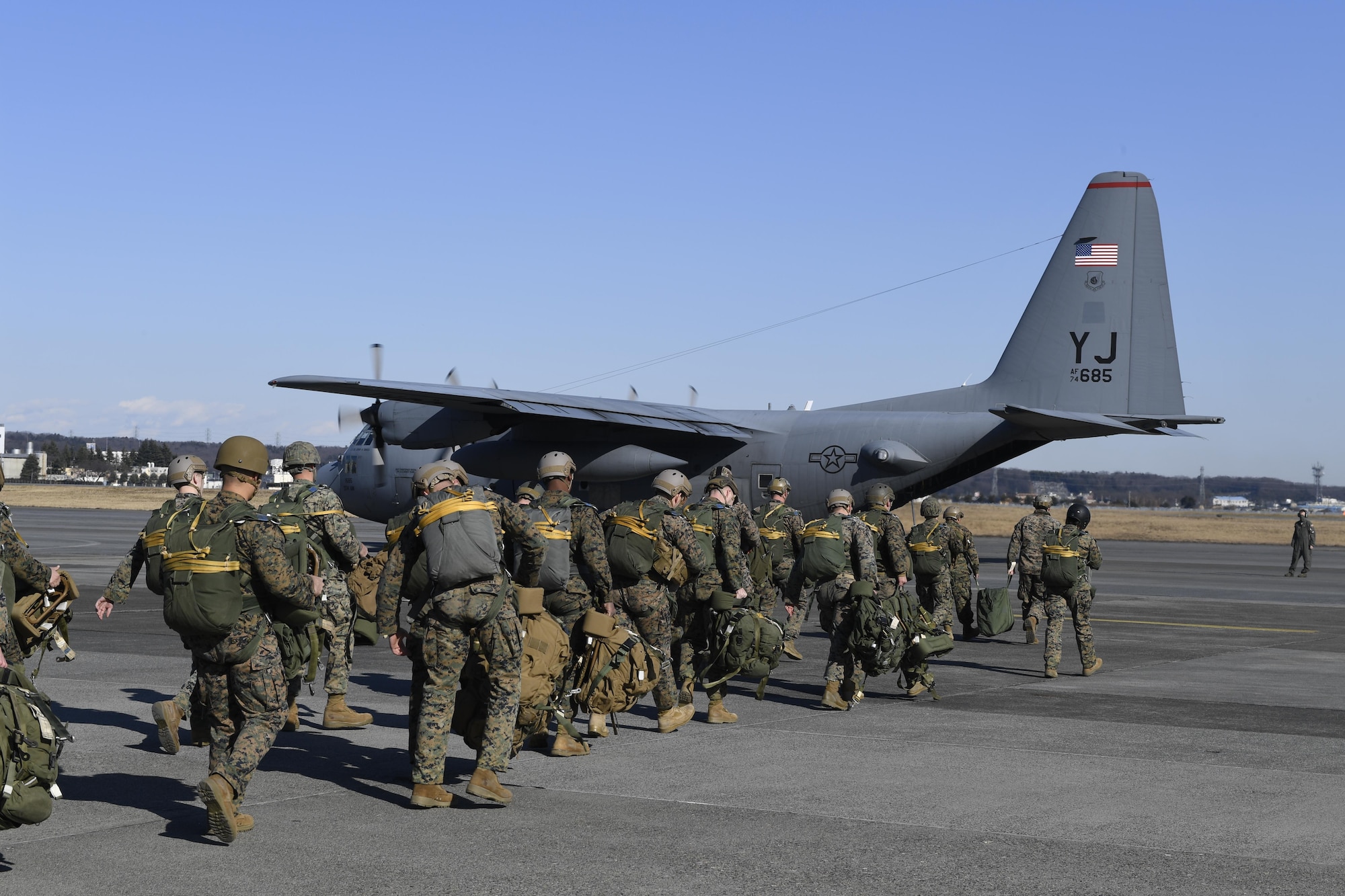 Marines with the 3rd Reconnaissance Battalion, 3rd Marine Division, III Marine Expeditionary Force, walk to a 36th Airlift Squadron C-130 Hercules before a static line parachute drop on Jan. 11, 2017, at Yokota Air Base, Japan. The Marines work with the 36 AS four times a year to help maintain jump qualifications and promote bilateral training. (U.S. Air Force photo by Airman 1st Class Donald Hudson)