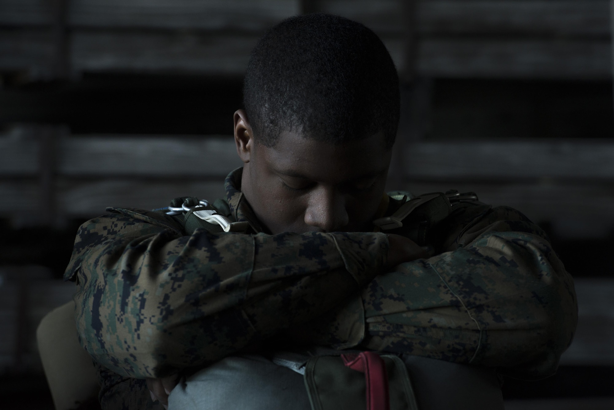 A Marine with the 3rd Reconnaissance Battalion, 3rd Marine Division, III Marine Expeditionary Force, rests in a hanger before a static line parachute drop on Jan. 11, 2017, at Yokota Air Base, Japan. The Marine unit spent the week working on their parachute qualifications practicing static line and high-altitude, low-opening jumps. (U.S. Air Force photo by Airman 1st Class Donald Hudson)