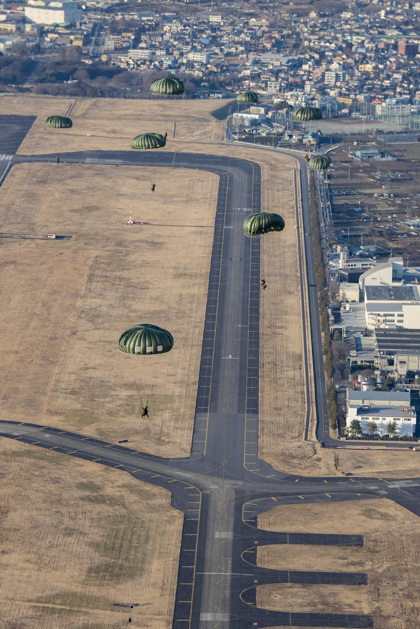 Marines with the 3rd Reconnaissance Battalion, 3rd Marine Division, III Marine Expeditionary Force, parachute to the ground after a static line jump on Jan. 11, 2017, at Yokota Air Base, Japan. The training allowed Marines to practice jumping while also allowing Yokota aircrews to practice flight tactics and timed-package drops. (U.S. Air Force photo by Airman 1st Class Donald Hudson)